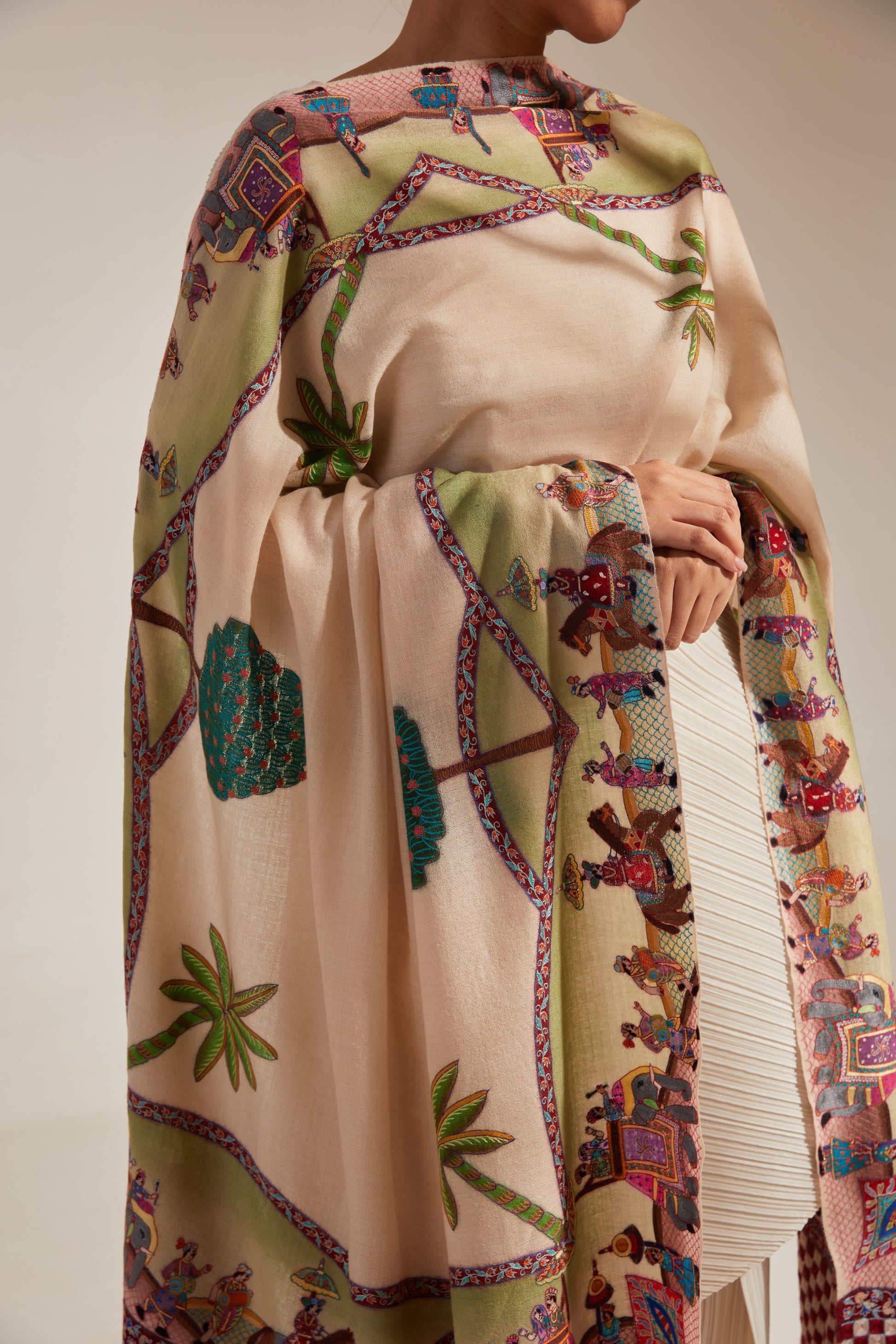 Model is wearing the Var Yatra Pashmina Kalamkari Shawl from Shaza, depicting a baraat procession as the border on a handloomed pashmina.
