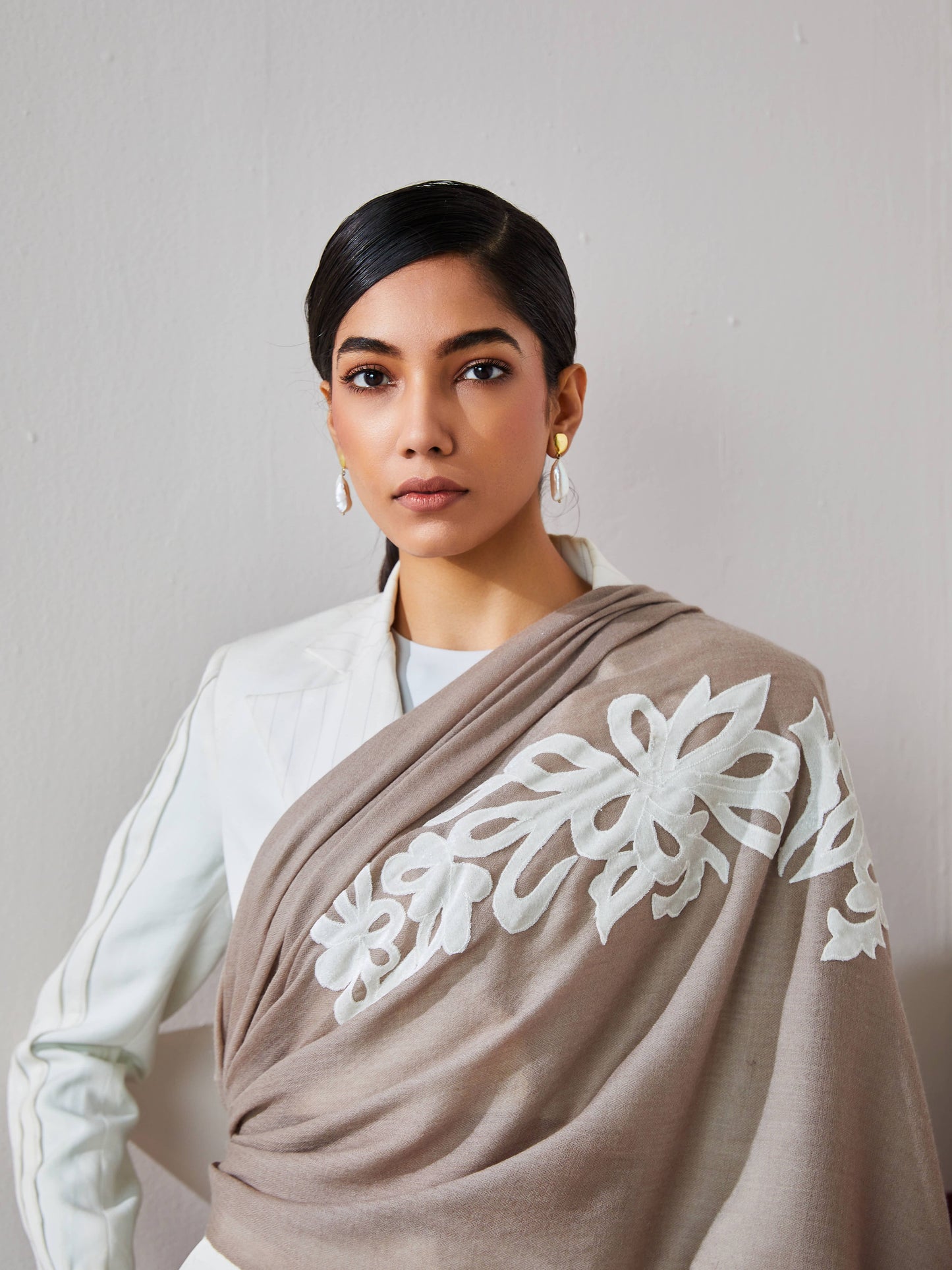 Model is wearing a brown Velvel affair cashmere stole with white applique from Shaza.