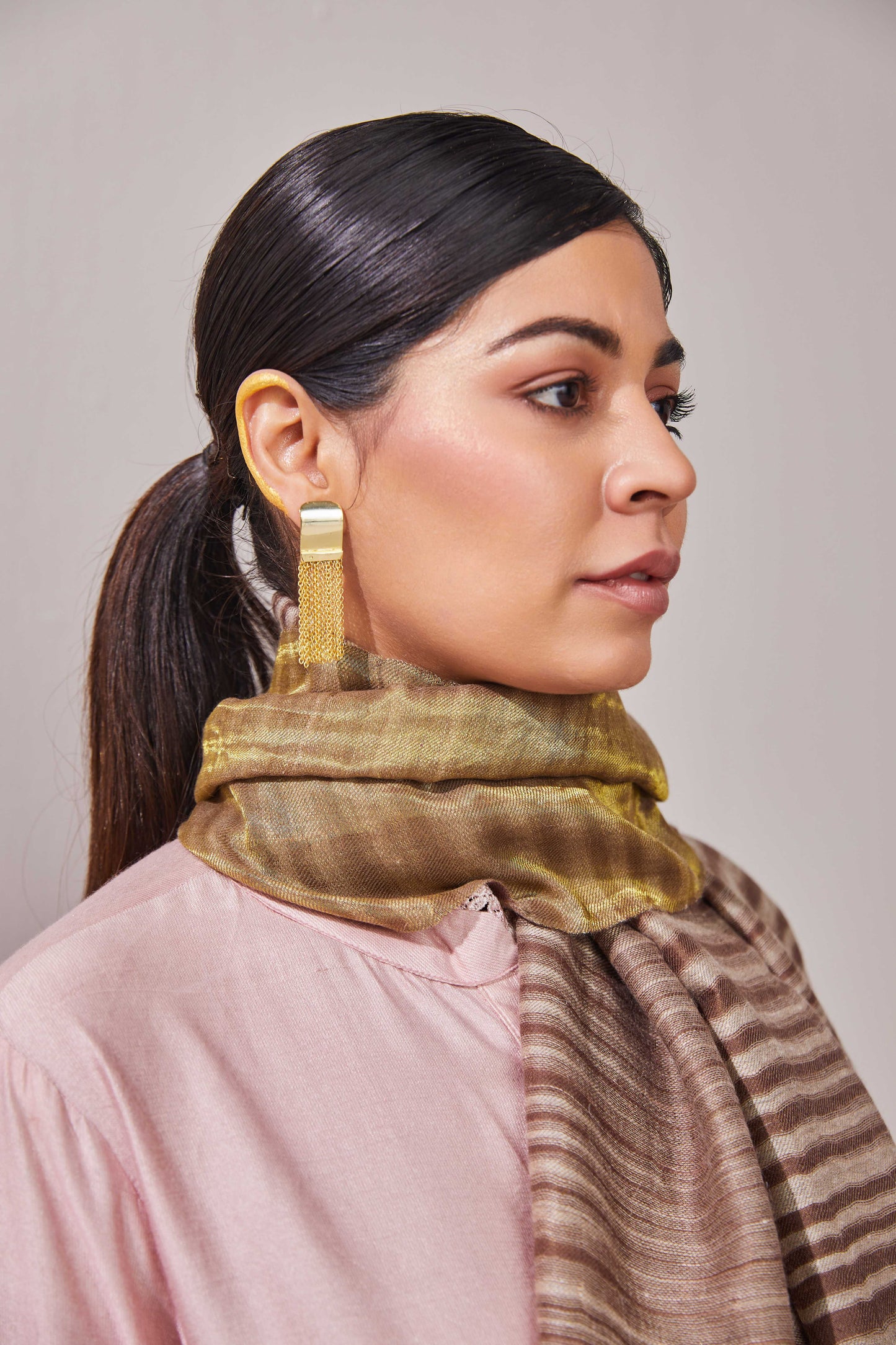 Model is wearing an Ekkat reversible stole in cedar brown from Shaza.