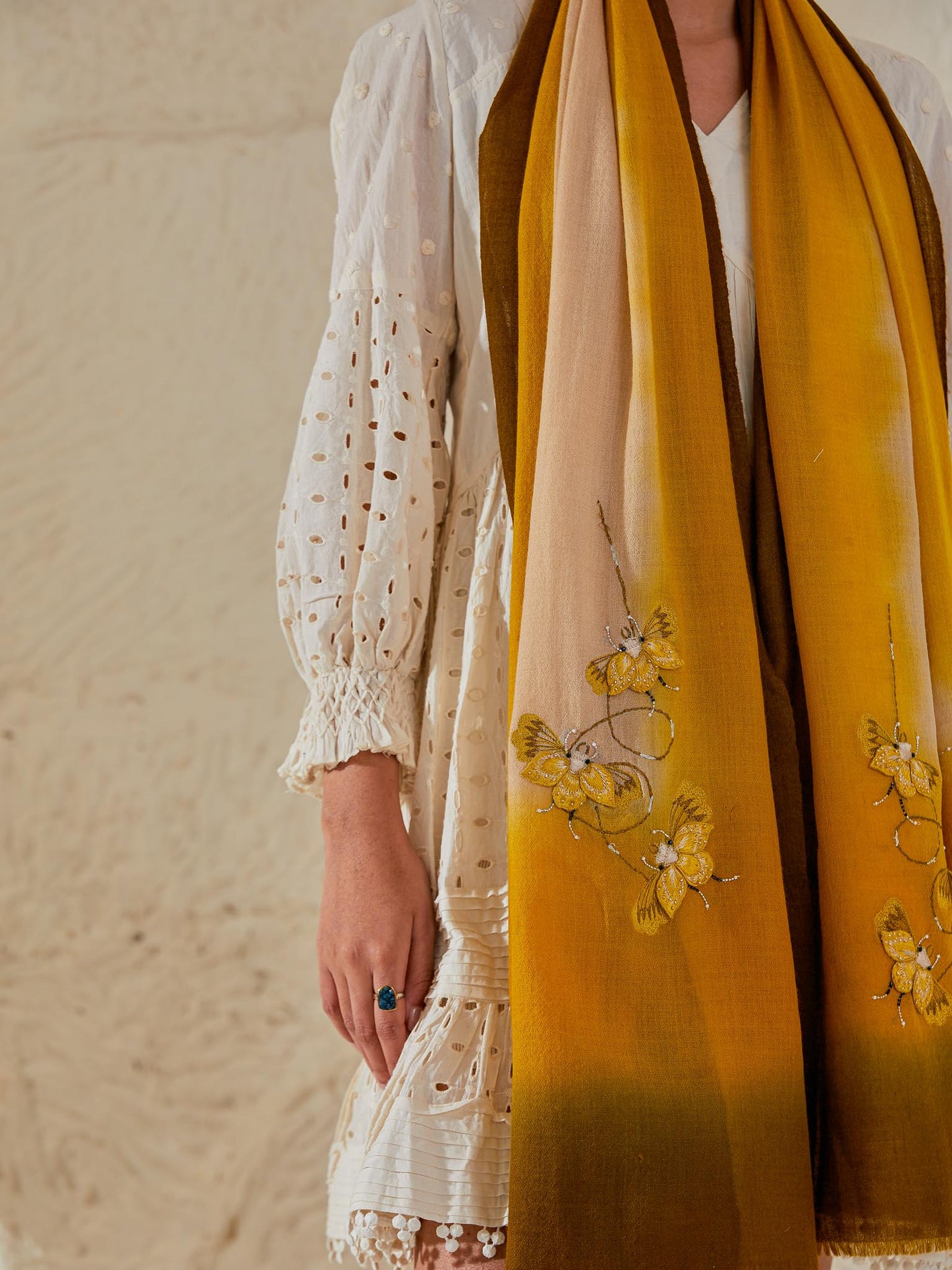 Model is wearing a Beetle pashmina stole from Shaza in the colour senescence, featuring threadwork beetle shapes uplifted with hand embroidered pearls, sequins and swarovski.