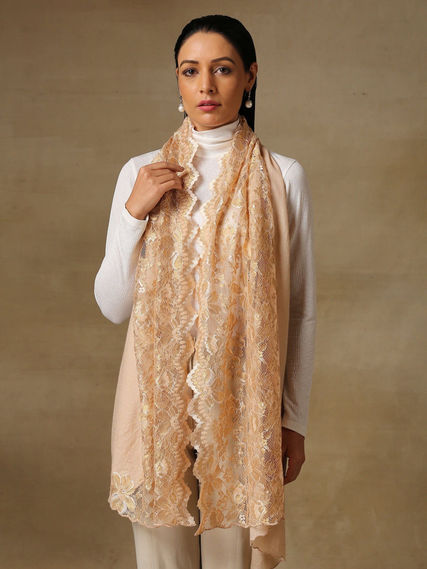 Model is wearing a Pashmina celestial chantilly stole in the colour gold.