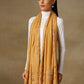 Model is wearing a Vineyard stole in the colour mustard, featuring vine shaped cutwork and zari detailing.