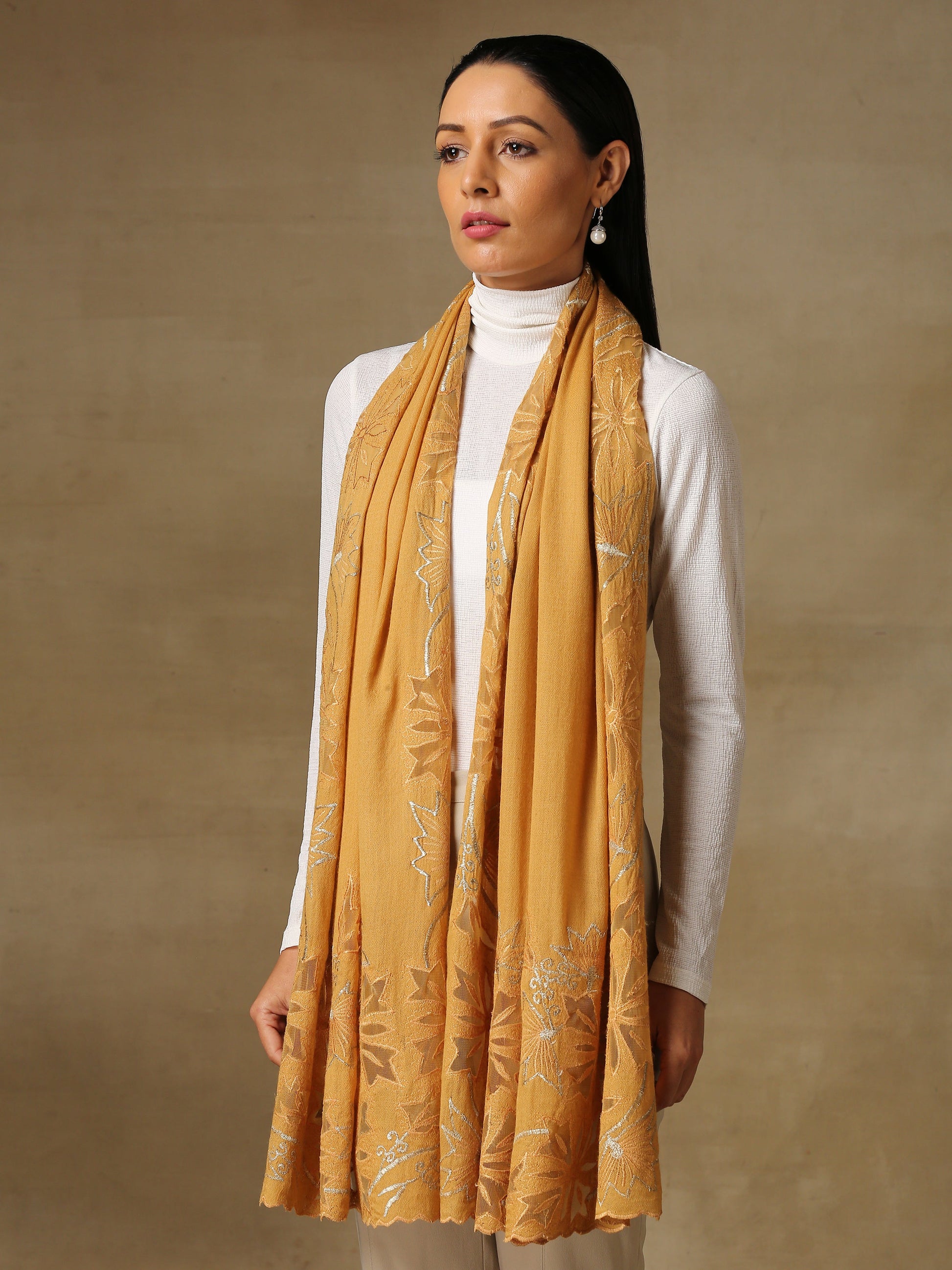 Model is wearing a Vineyard stole in the colour mustard, featuring vine shaped cutwork and zari detailing.