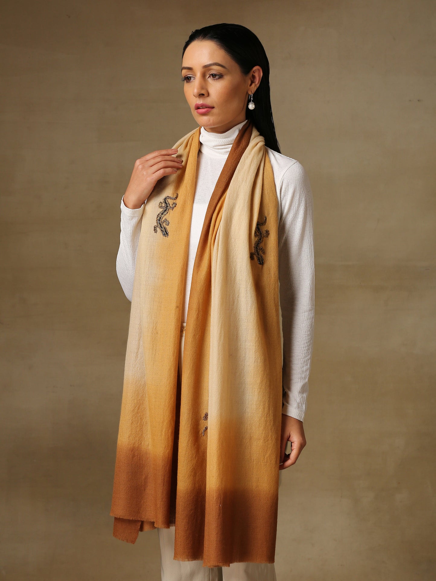 Model is wearing a Reptile Pashmina stole from shaza, featuring a hand painted ombre in the colour soil and tinsel and swarovski adorned sinuous shapes.