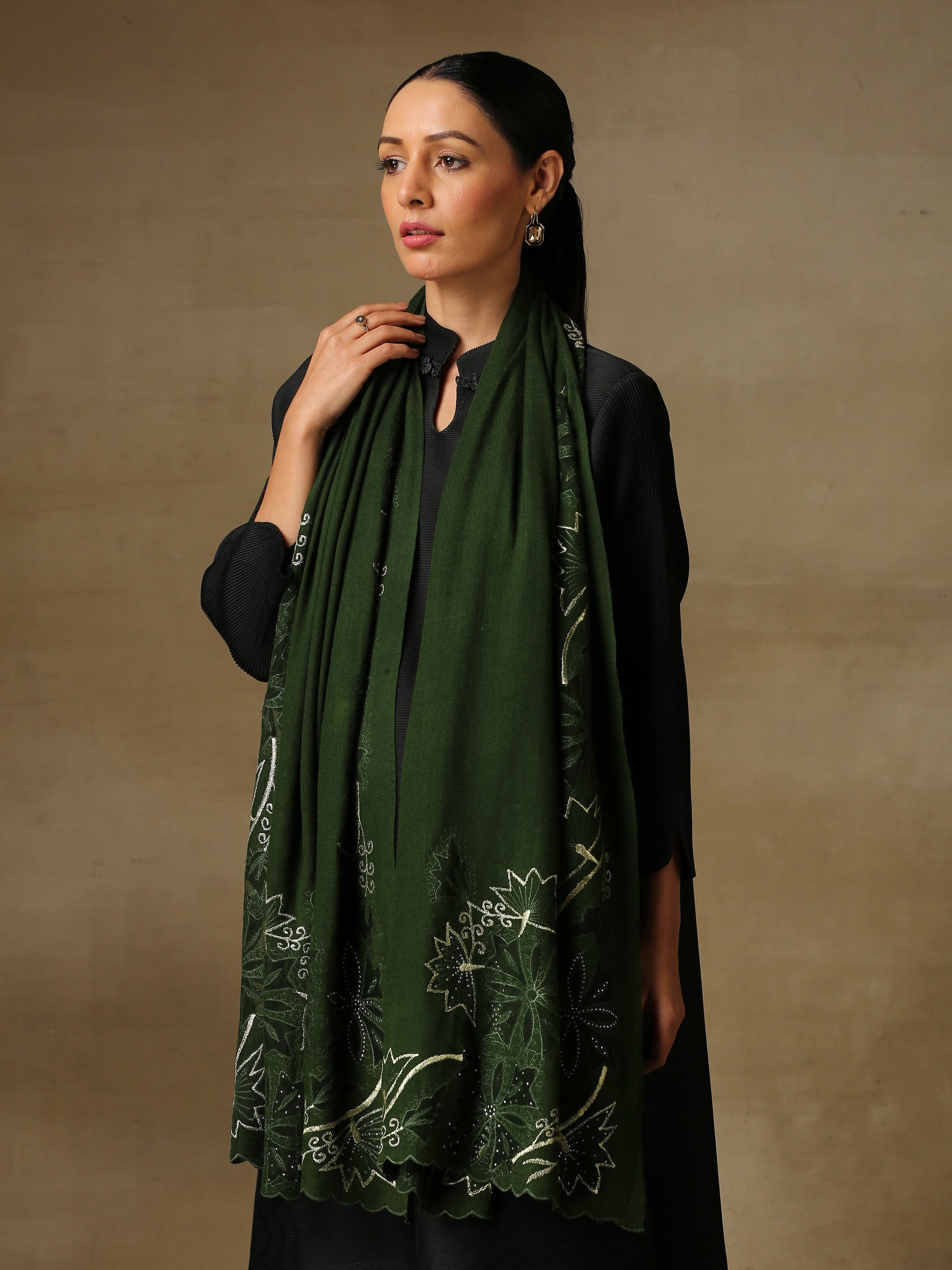 Model is wearing a Vineyard Zaywar stole featuring cutwork vine pattern bordered with zari details and hand embellished with fine swarovski, in a green colour.