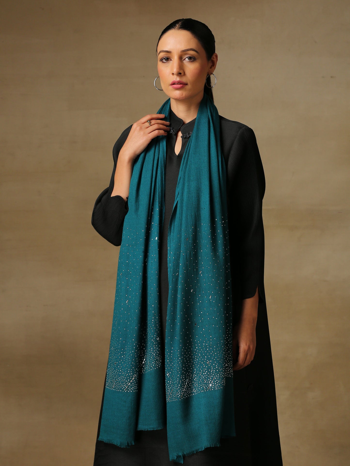 Model is wearing a swarovksi studded Era of Zaywar Palla Stole in the colour emerald. .