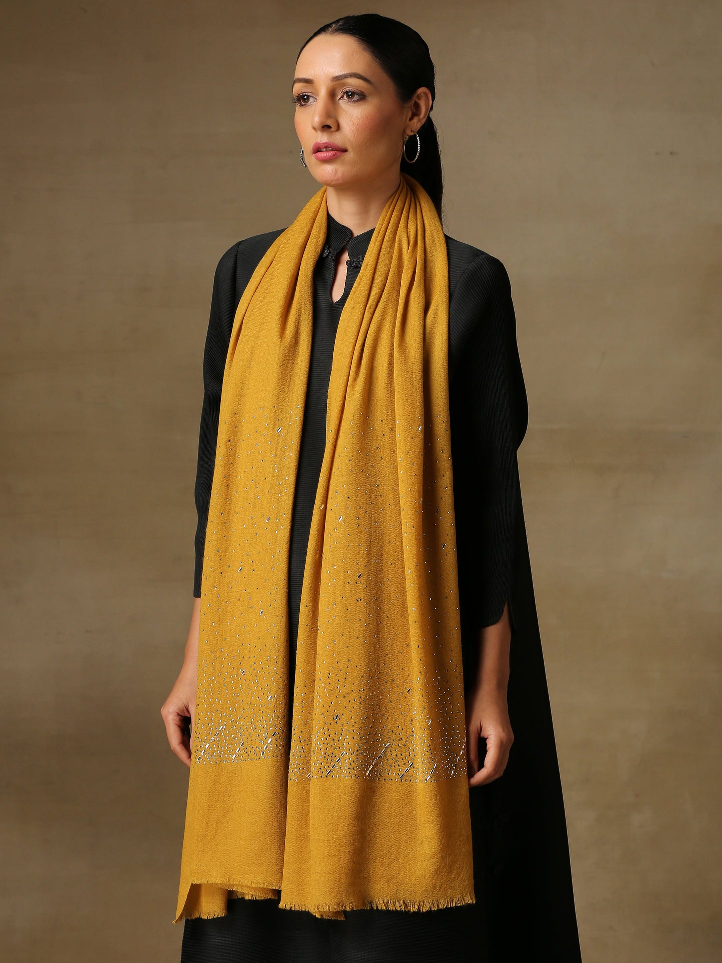 Model is wearing a swarovksi studded Era of Zaywar Palla Stole in the colour mustard. .