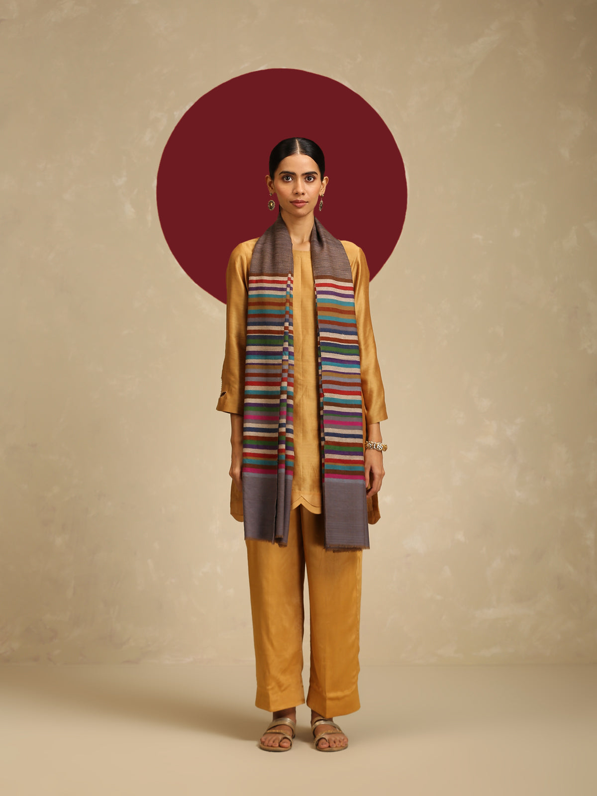 Model is wearing Qazah Stole with multicoloured stripes on a gray base