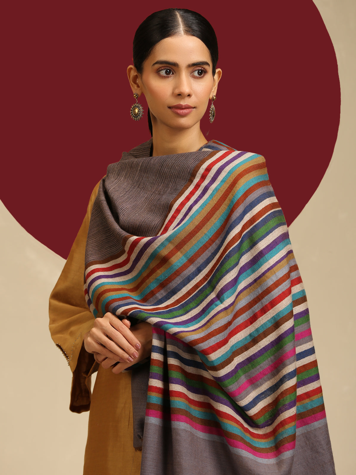 Model is wearing Qazah Stole with multicoloured stripes on a gray base