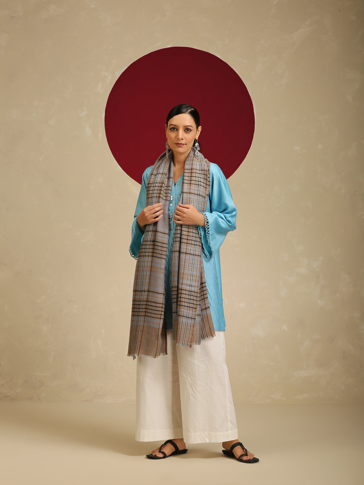 Model is wearing a Pashmina Check stole from Shaza with black and blue cross lines on a toosh coloured base.