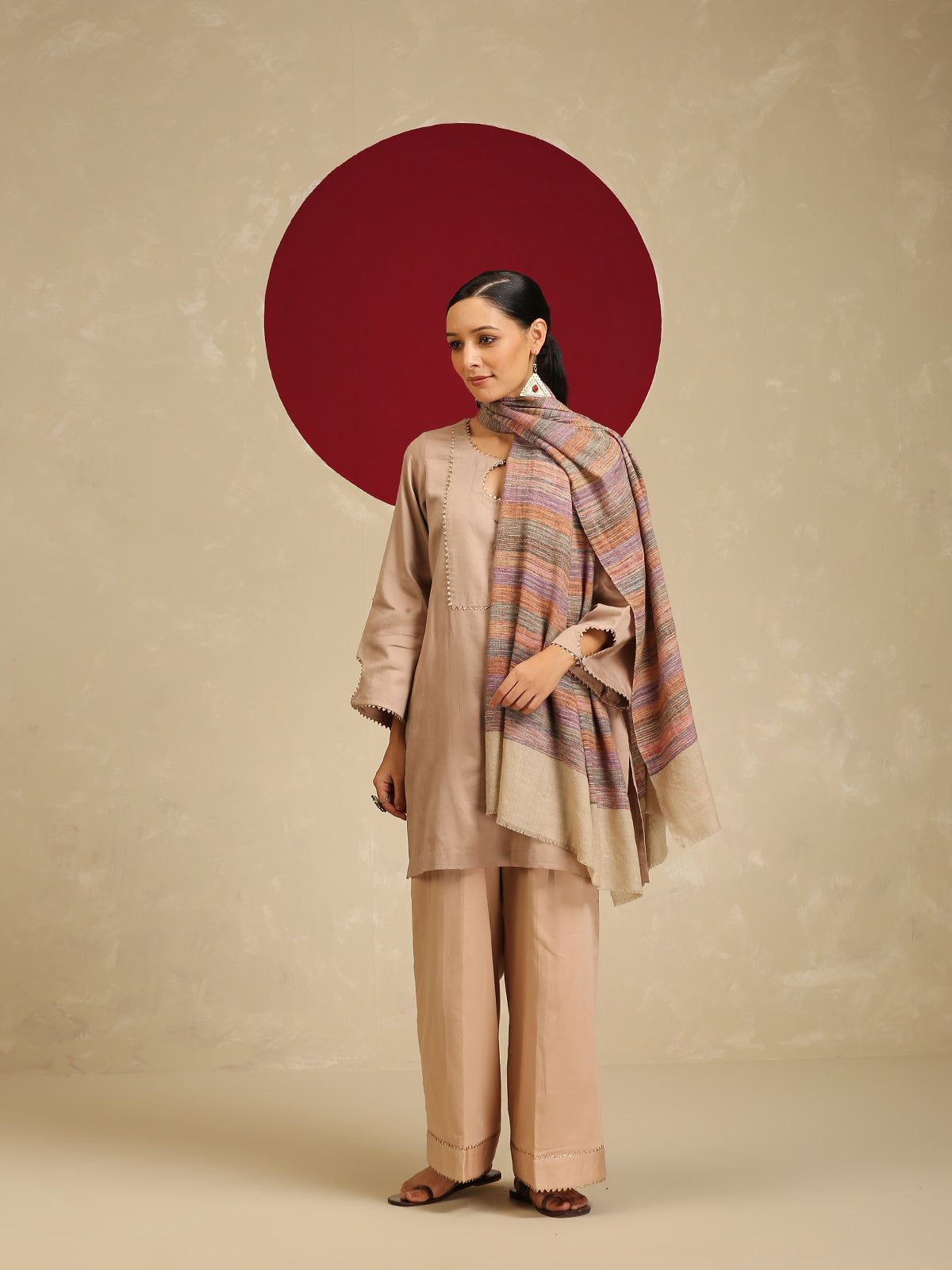 Model is wearing a Pashmina Stripe Stole featuring multicolour stripes on a light gray base.