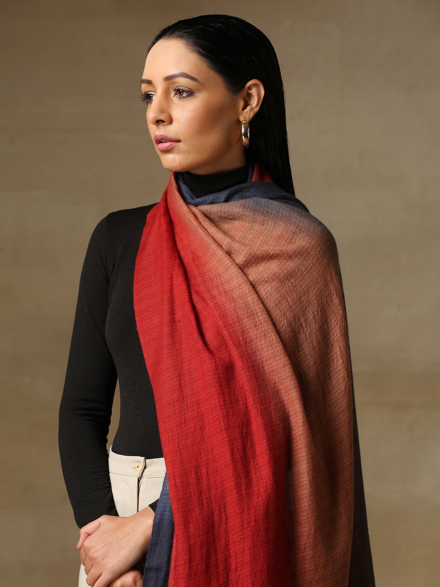 Model is wearing a Pashmina Ombre stole in self weave in the colours crimson orange & blue.