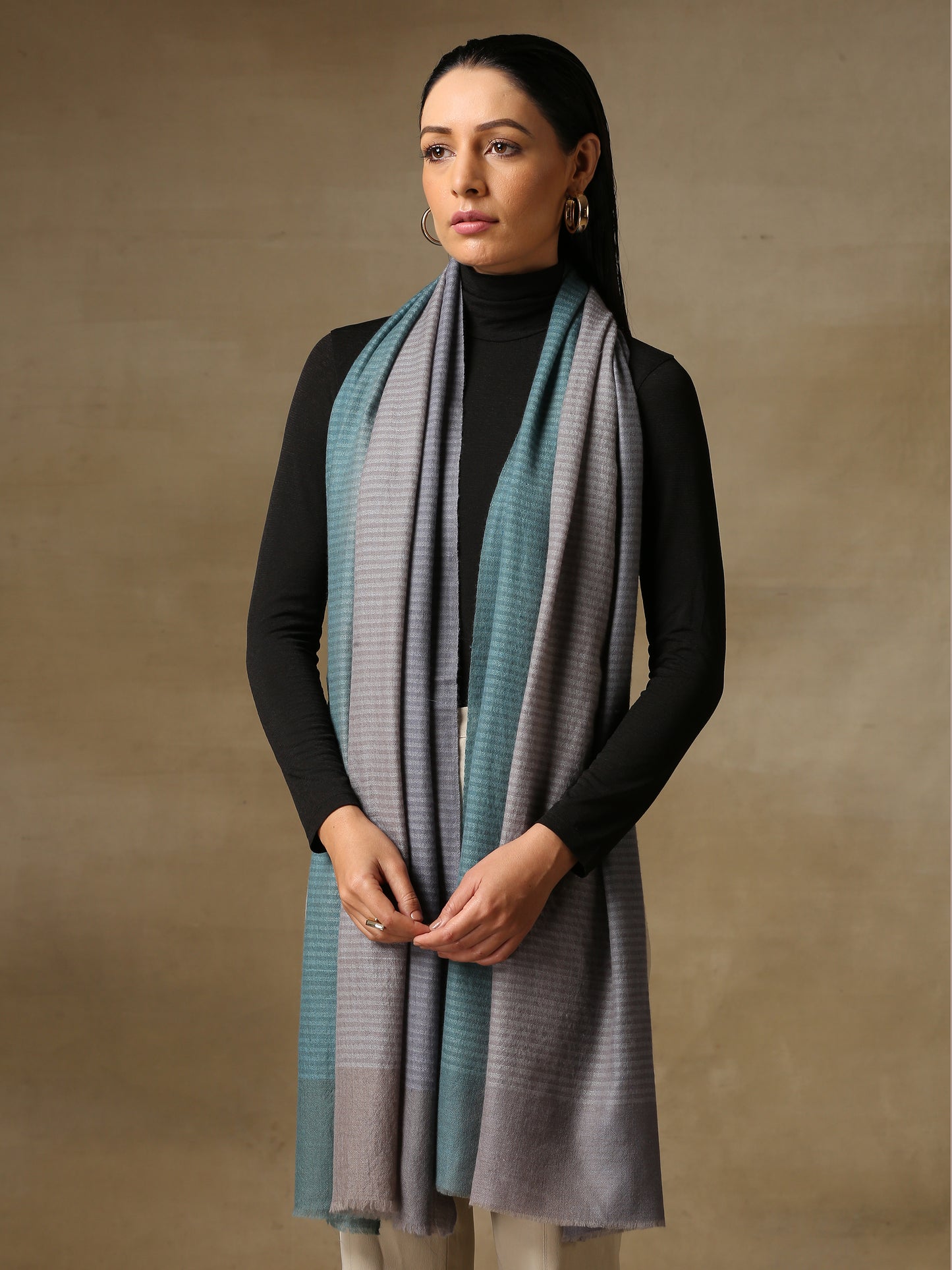 Model is wearing a Pashmina Ombre stole in Self weave in the colour silver.