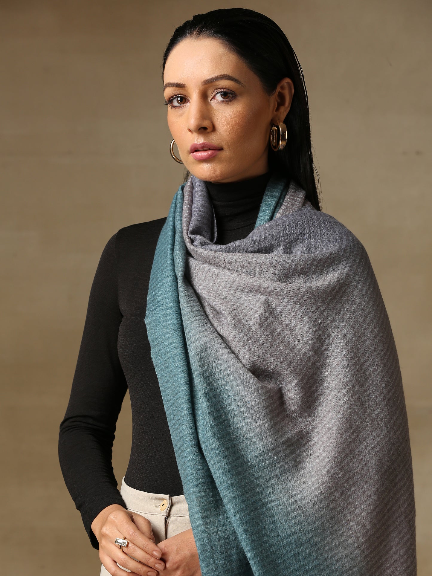 Model is wearing a Pashmina Ombre stole in Self weave in the colour silver.