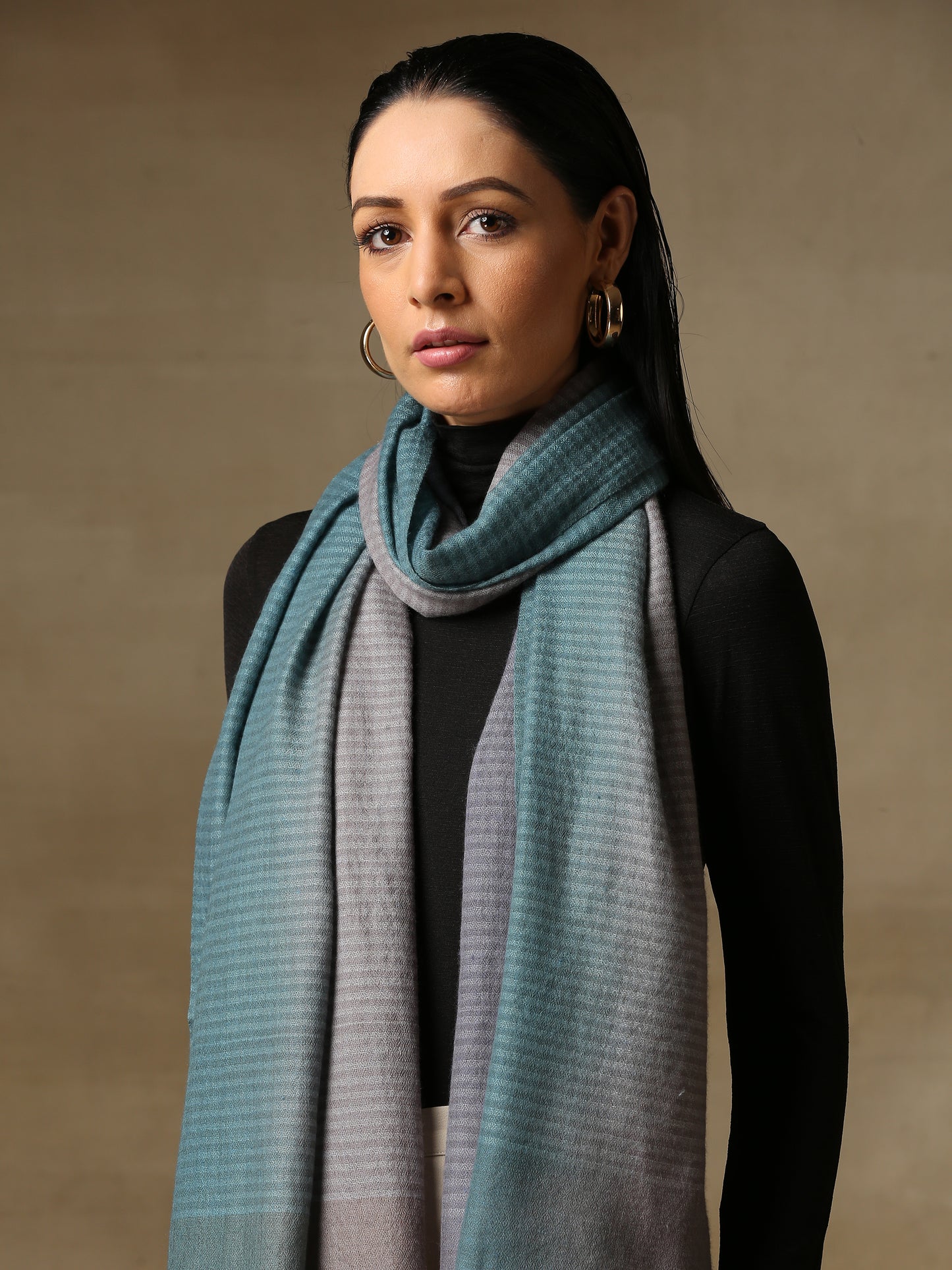 Model is wearing a Pashmina Ombre stole in Self weave in the colour silver.