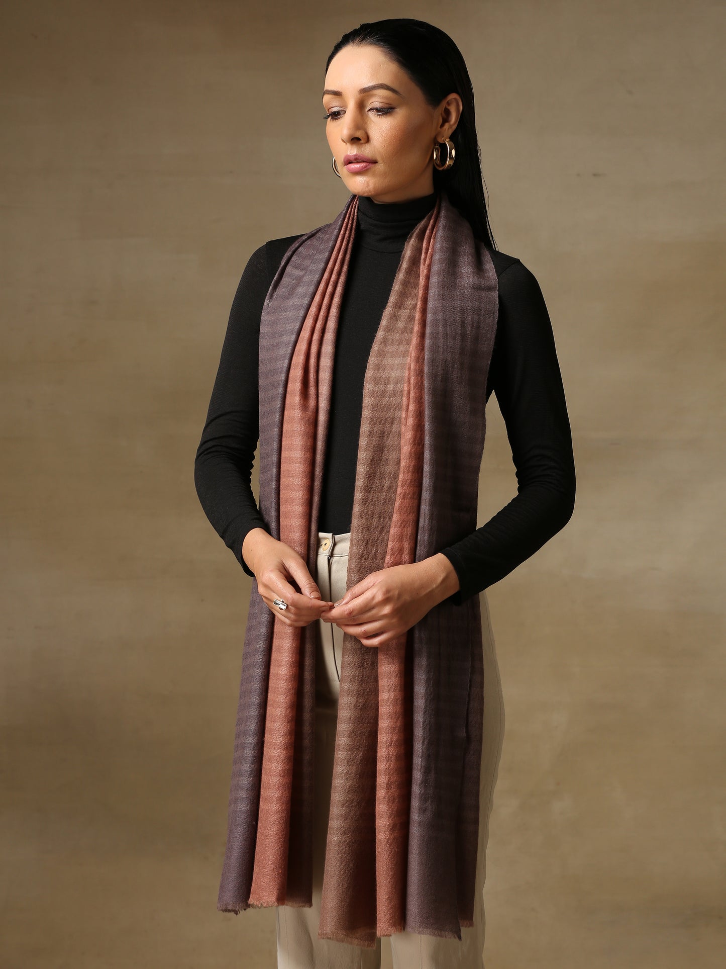 Model is wearing a Pashmina ombre stole in self weave in the colour dusky orange.