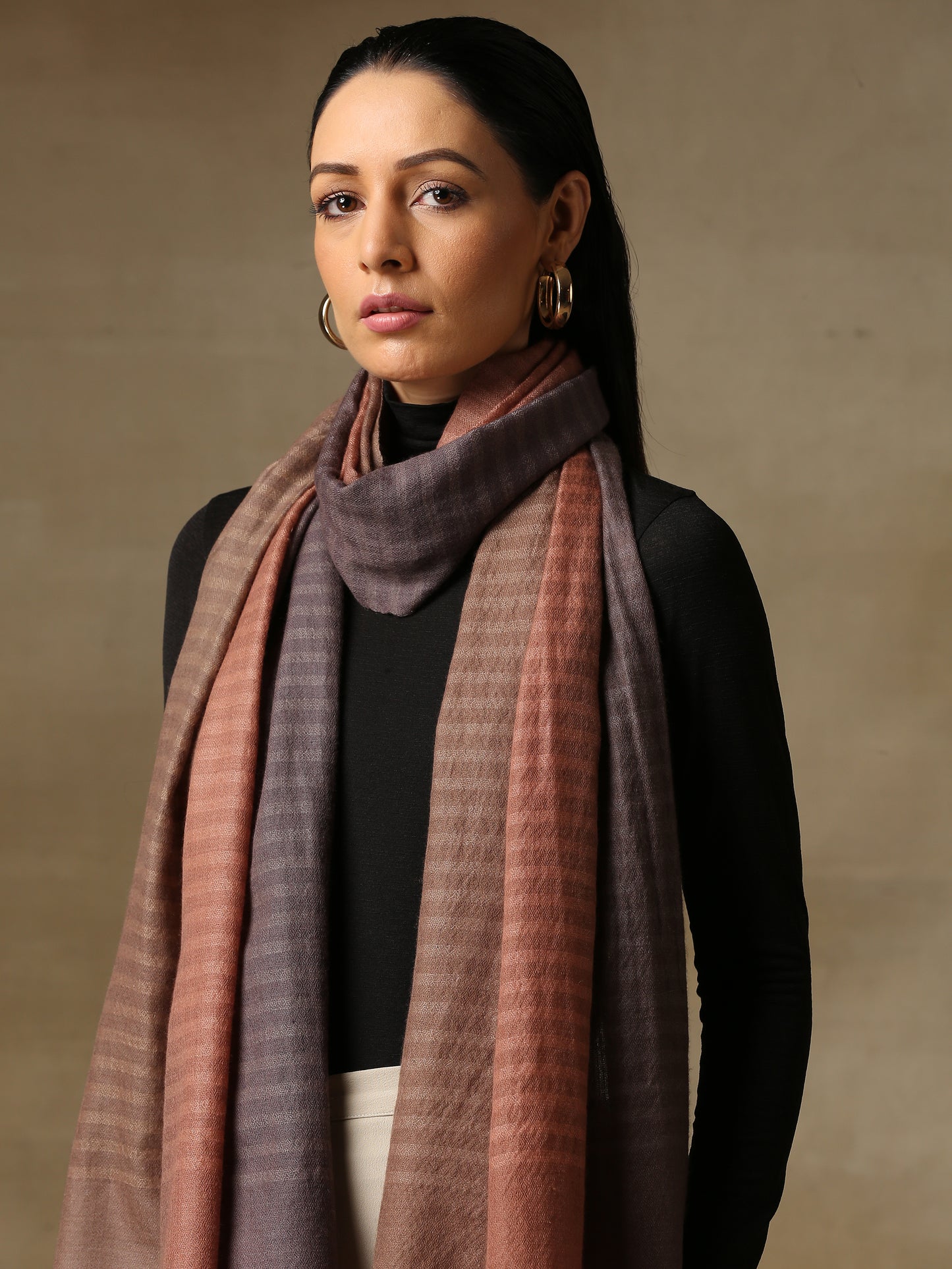 Model is wearing a Pashmina ombre stole in self weave in the colour dusky orange.