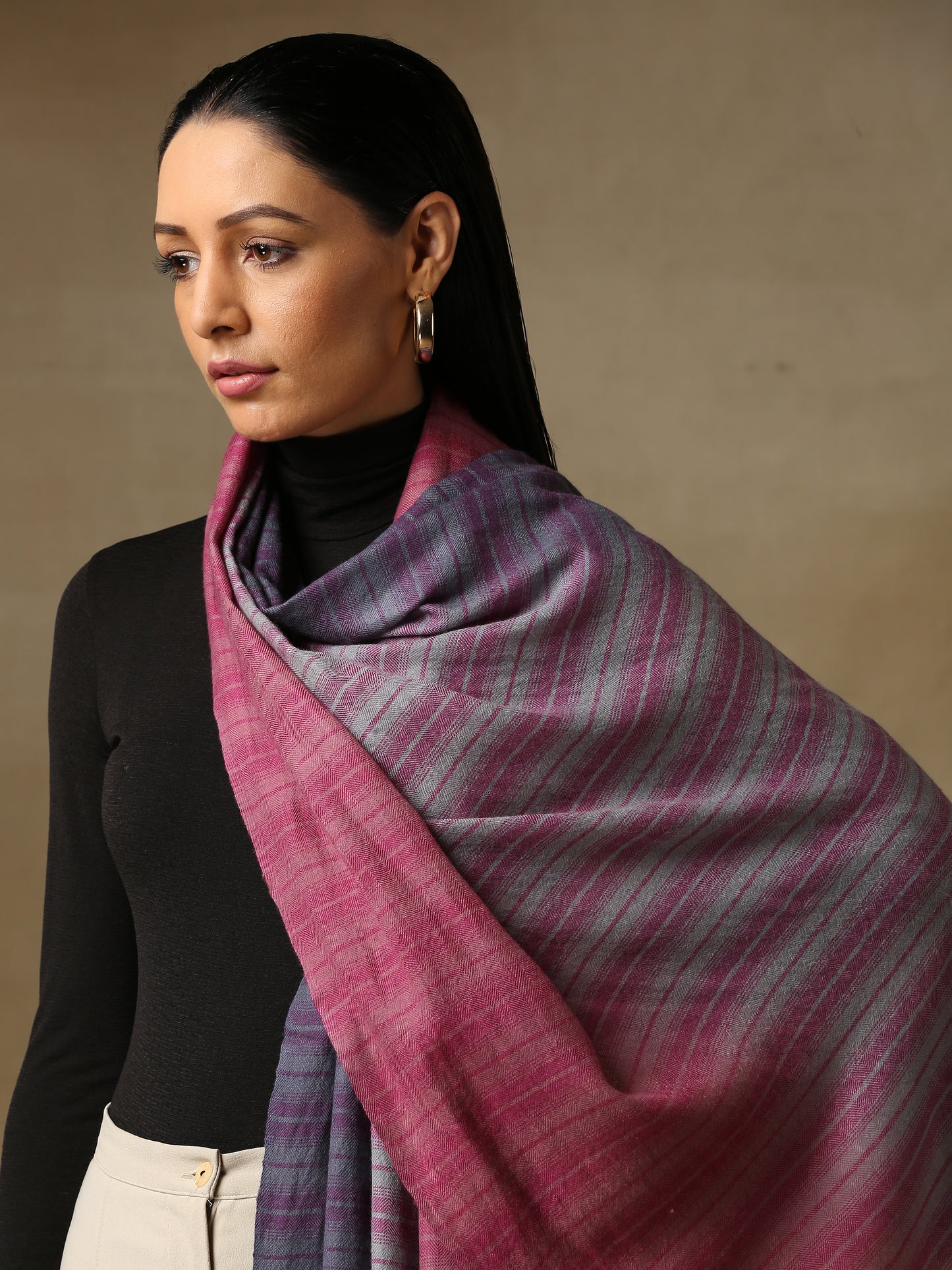 Model is wearing a Pashmina Ombre stole in self weave in the colours gray, pink & purple.