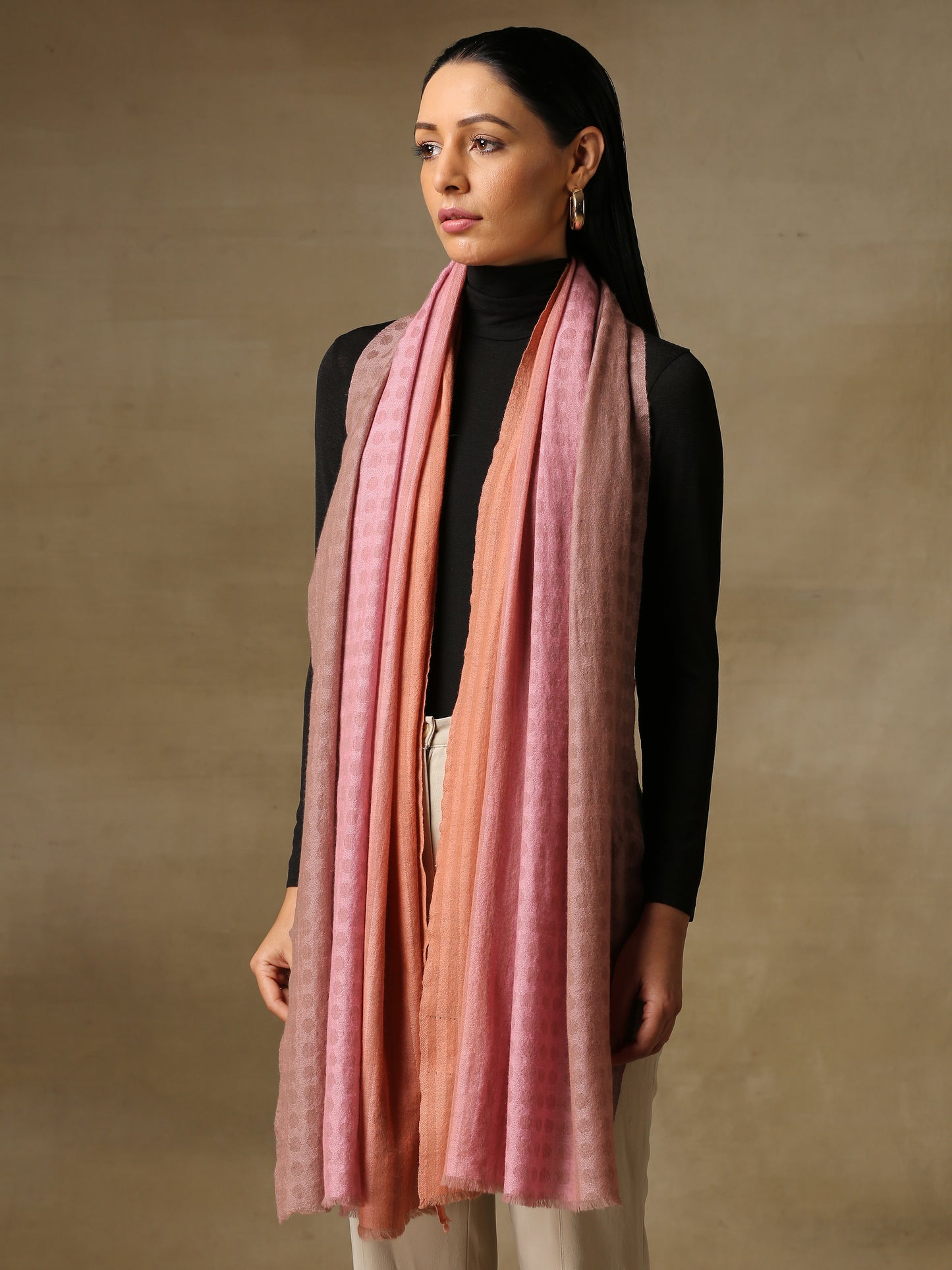 Model is wearing pashmina ombre in self weave stole in colours of baby pink and peach.