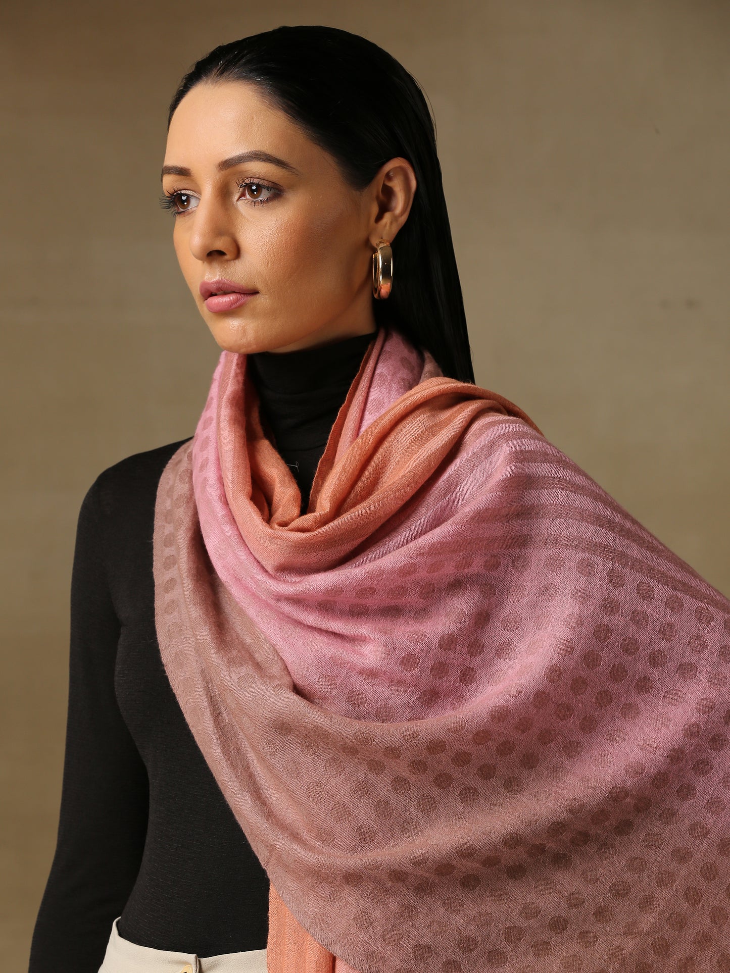 Model is wearing pashmina ombre in self weave stole in colours of baby pink and peach.
