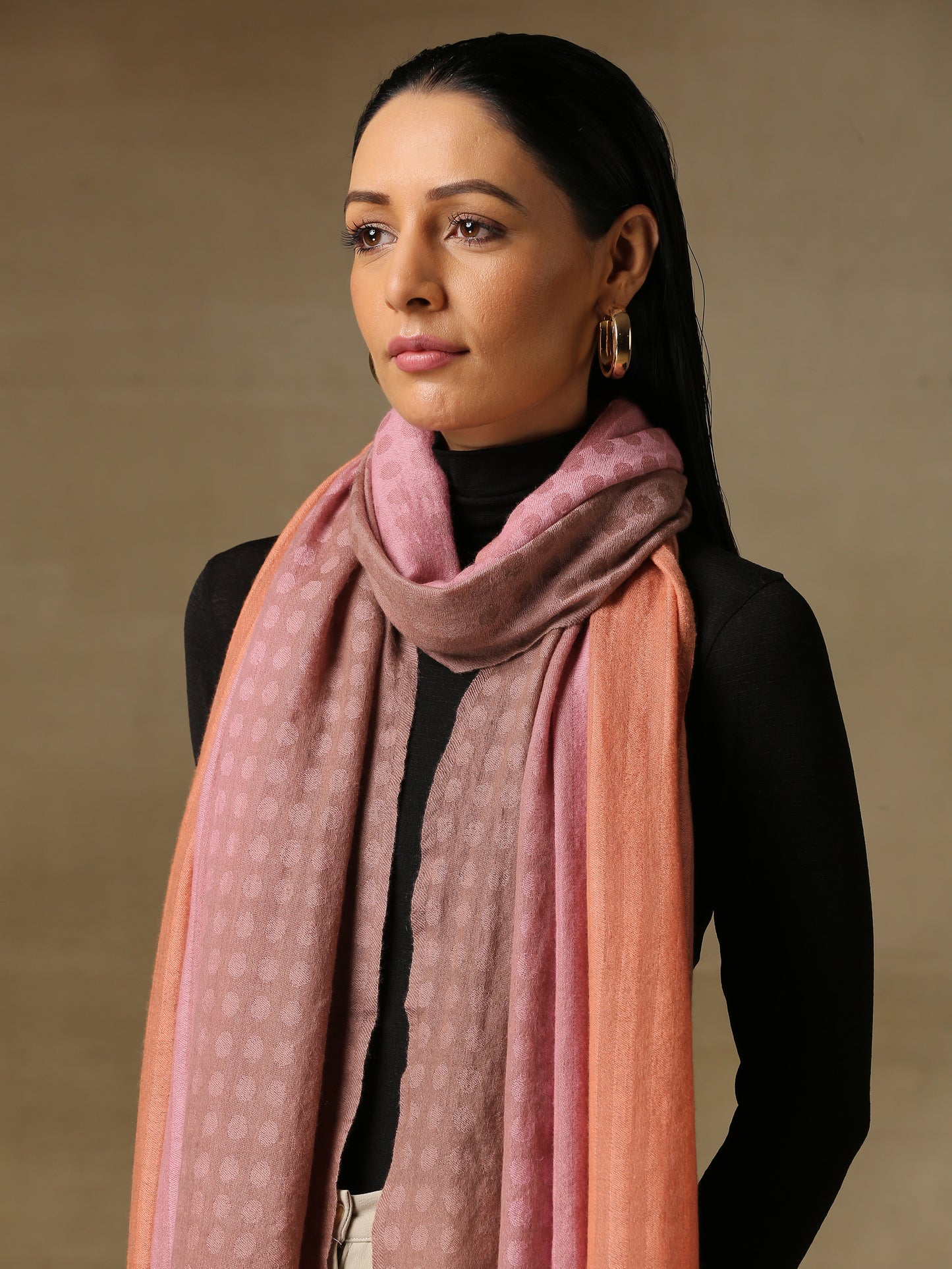 Model is wearing pashmina ombre in self weave stole in colours of baby pink and peach.