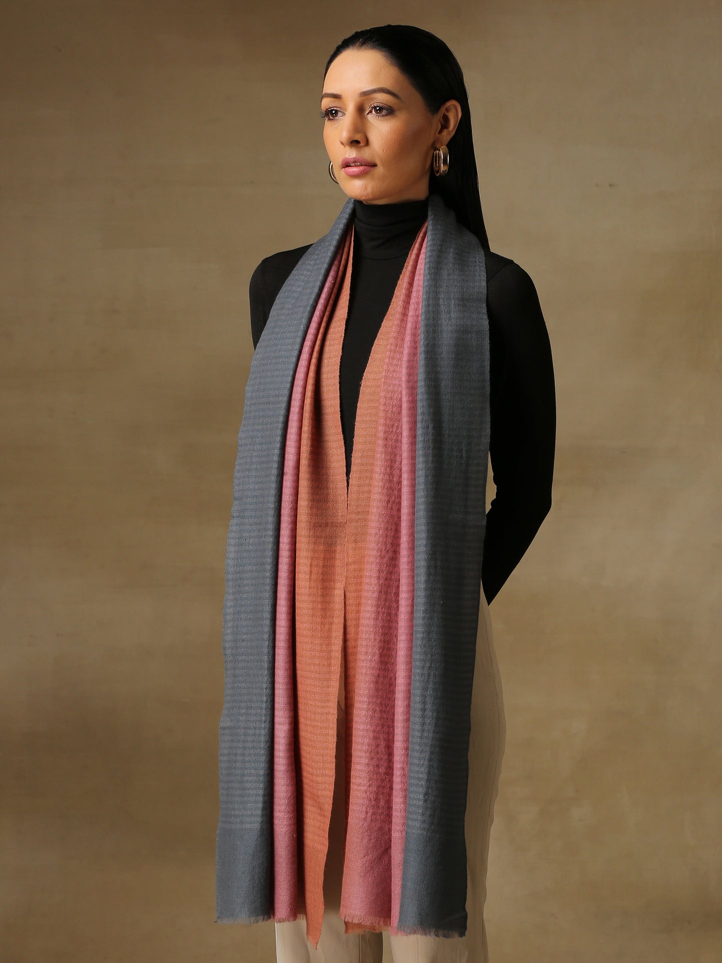 Model is wearing Pashmina Ombre stole in self weave in gray, blush pink & orange colours.