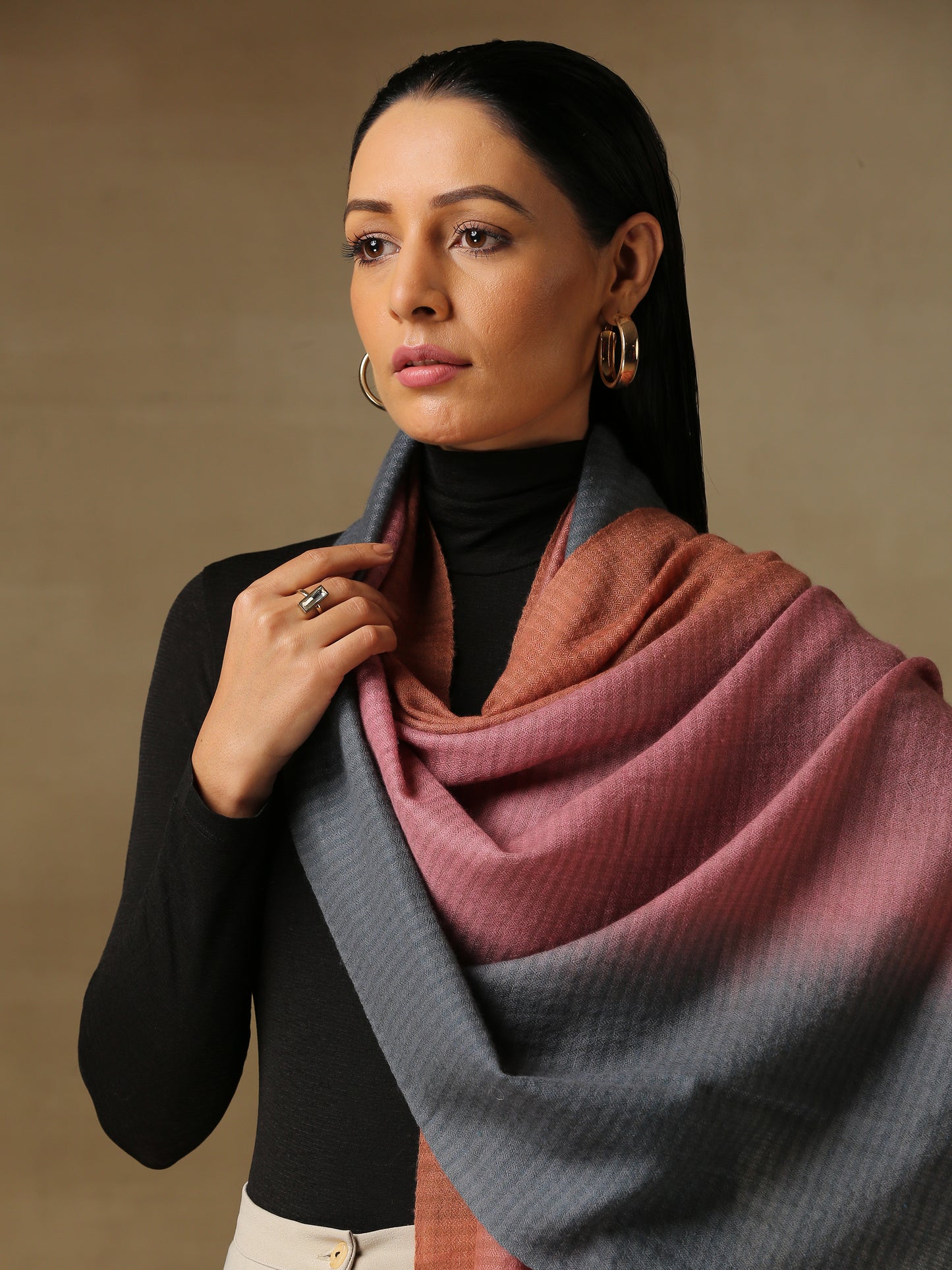 Model is wearing Pashmina Ombre stole in self weave in gray, blush pink & orange colours.