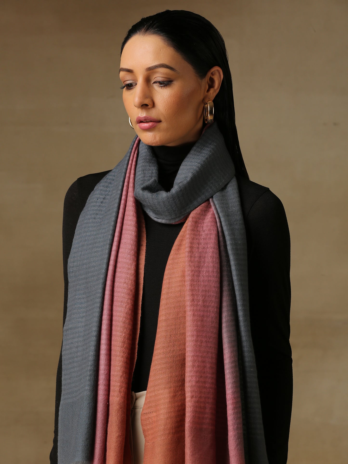 Model is wearing Pashmina Ombre stole in self weave in gray, blush pink & orange colours.