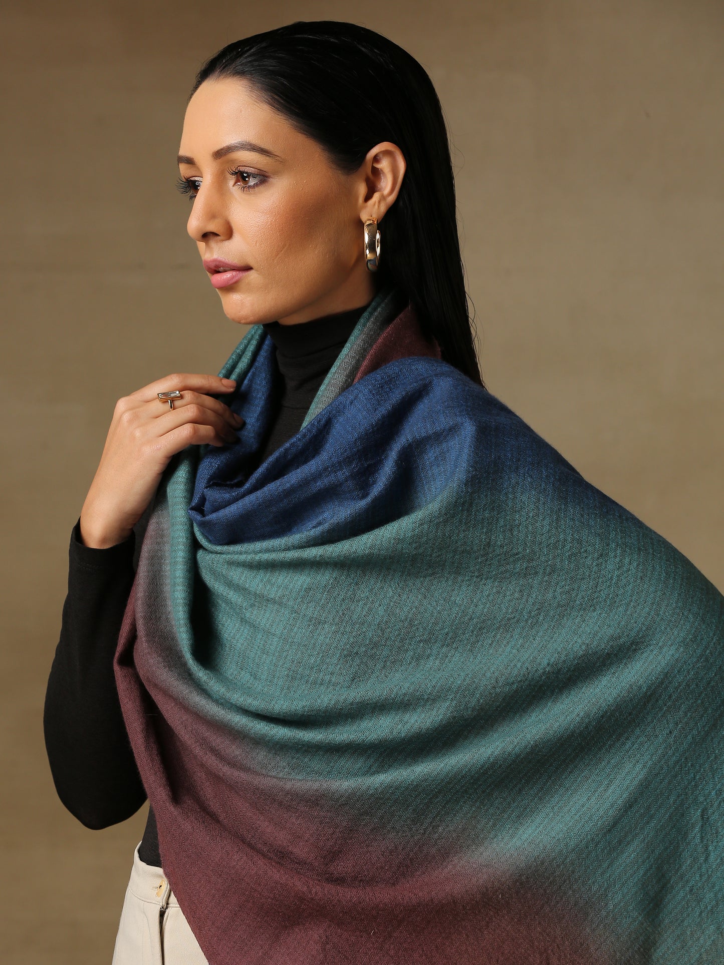 Model is wearing a Pashmina Ombre stole in Self weave in the colours turquoise and maroon.