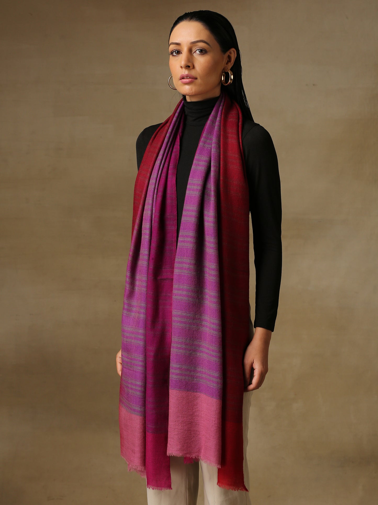 Model is wearing a Pashmina Ombre stole in Self weave in the colours violet and red.