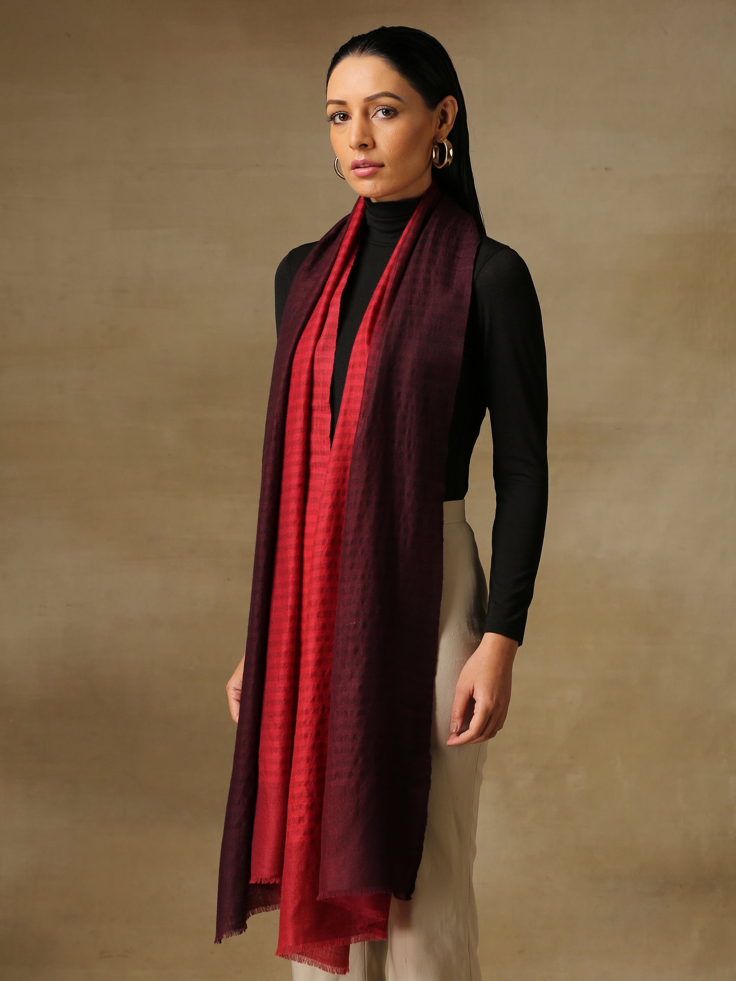 Model is wearing a Pashmina Ombre stole in self weave in the the colours maroon & red.