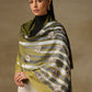 Model is wearing a cashmere machine embroidery stole from Shaza, featuring threadwork floral motifs, in the colour olive.