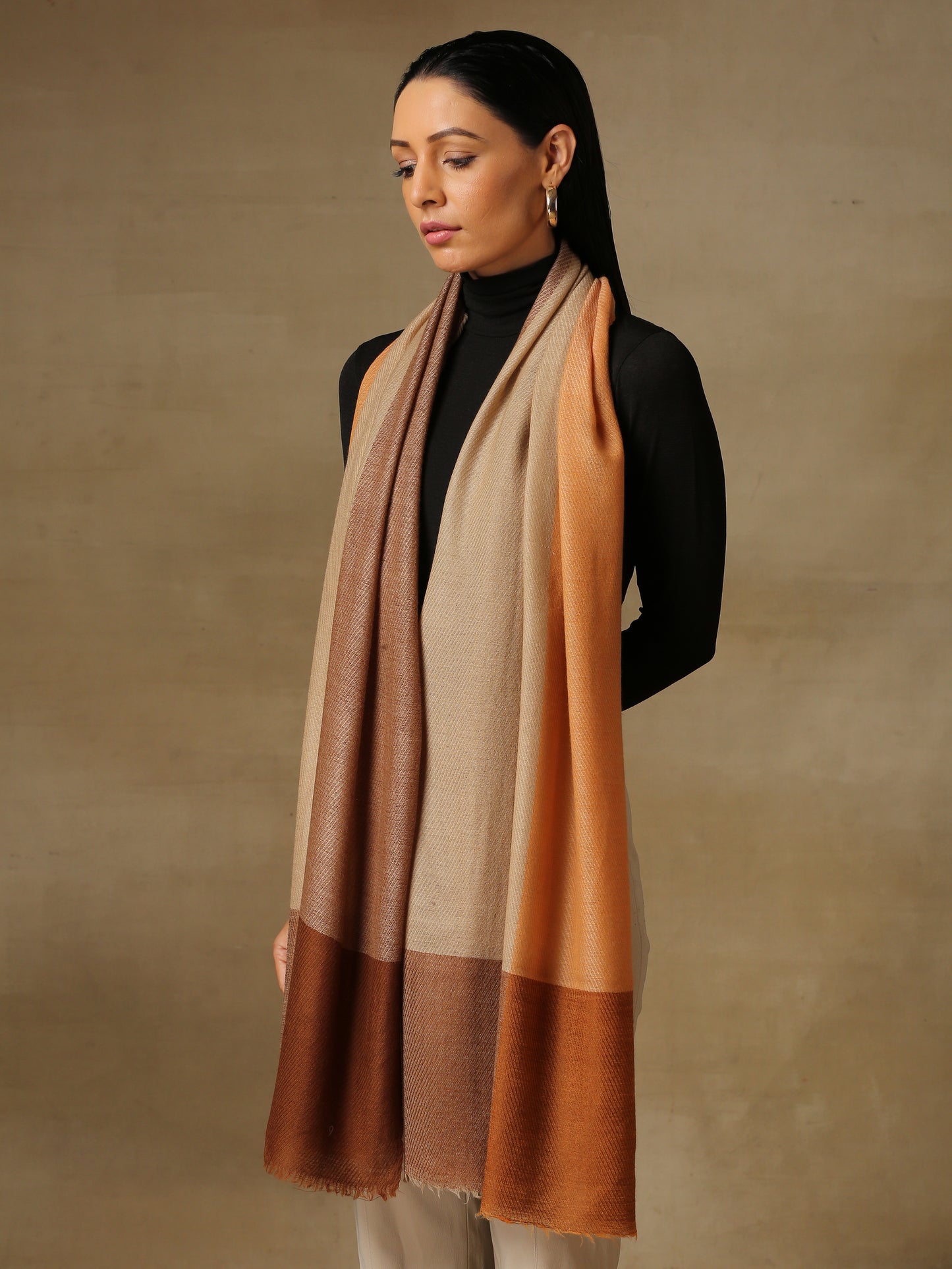 Model is wearing a Pardah stole by Shaza in orange and natural.