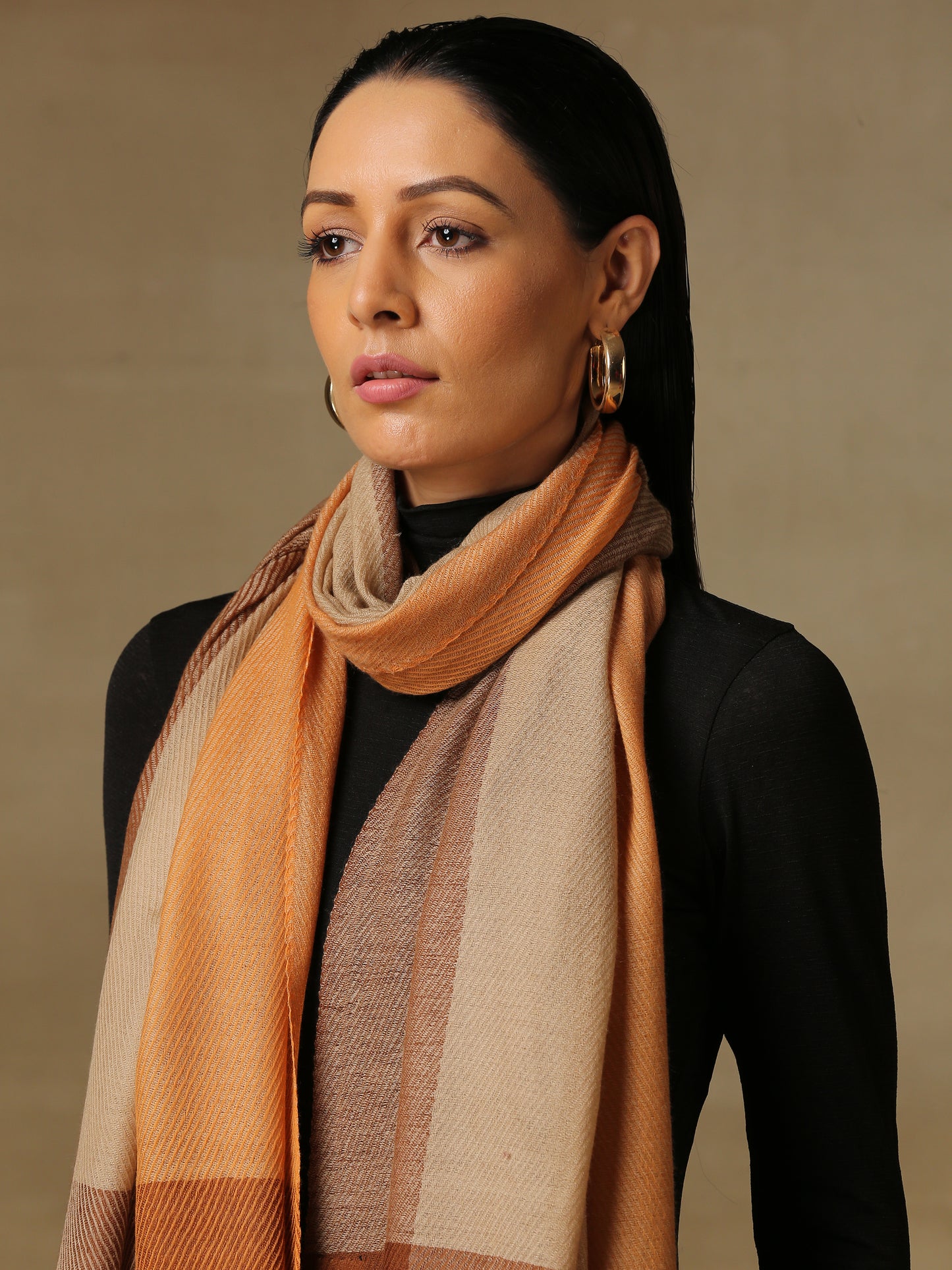 Model is wearing a Pardah stole by Shaza in orange and natural.