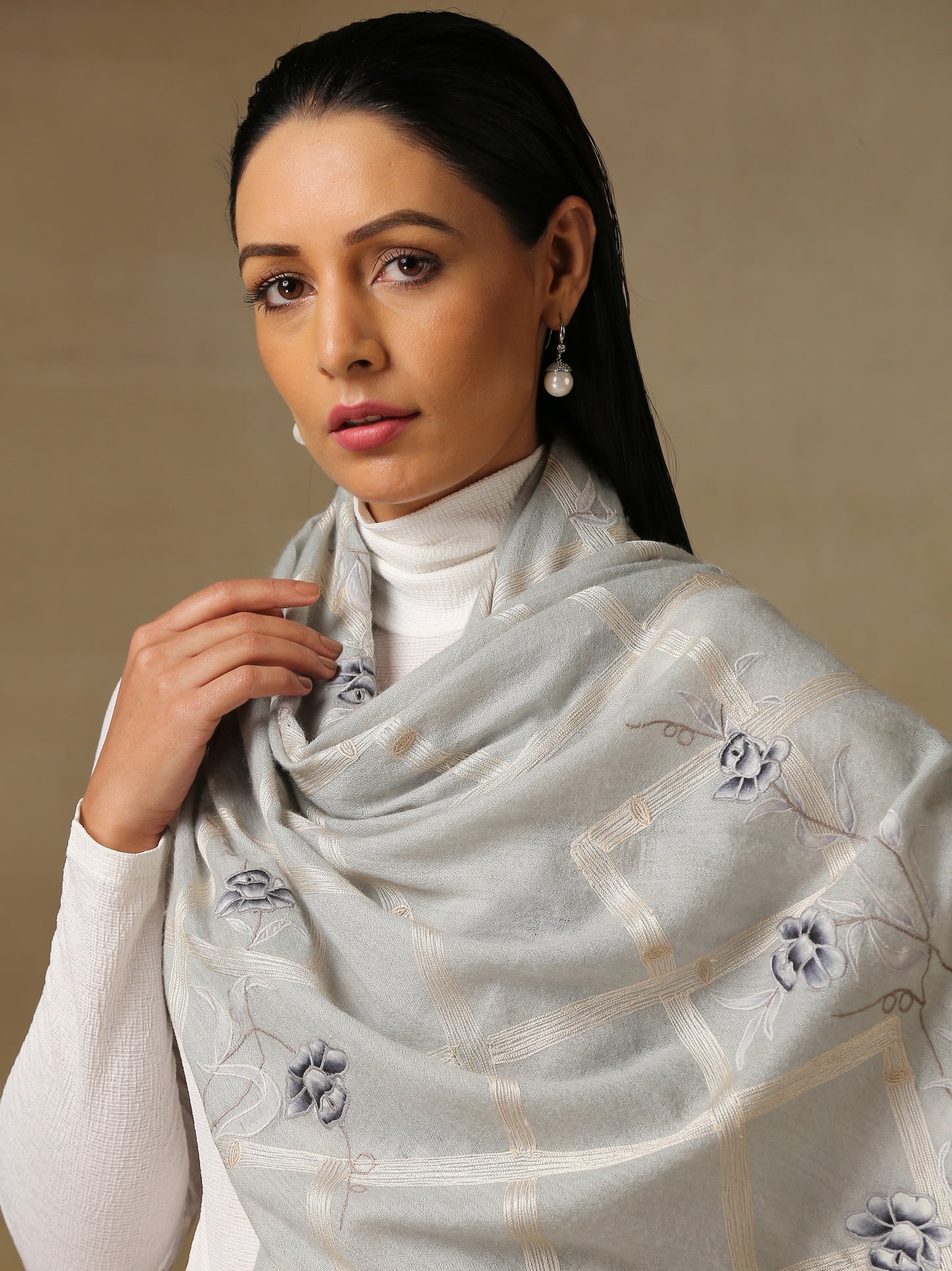 Model is wearing the Daisy pashmina stole in Ice blue from Shaza, featuring threadwork of interwoven lines and applique of daisy figures on handloomed pashmina.