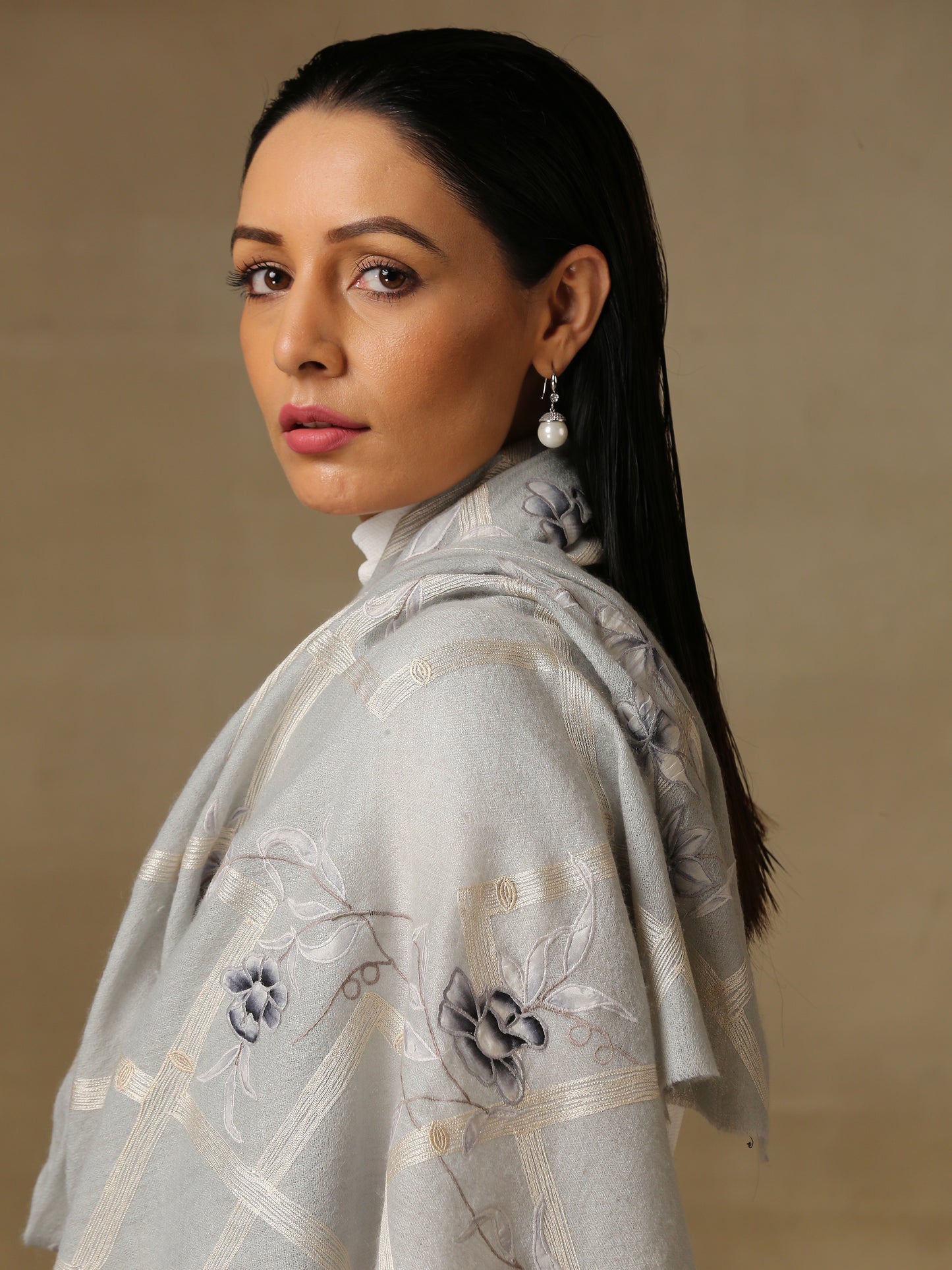 Model is wearing the Daisy pashmina stole in Ice blue from Shaza, featuring threadwork of interwoven lines and applique of daisy figures on handloomed pashmina.