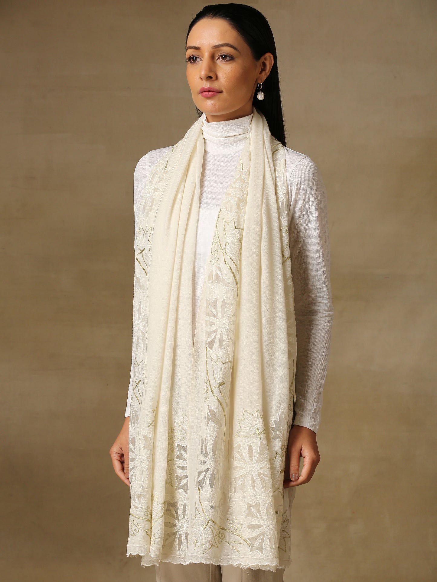 Model is wearing a Vineyard stole in the colour white, featuring vine shaped cutwork and zari detailing.