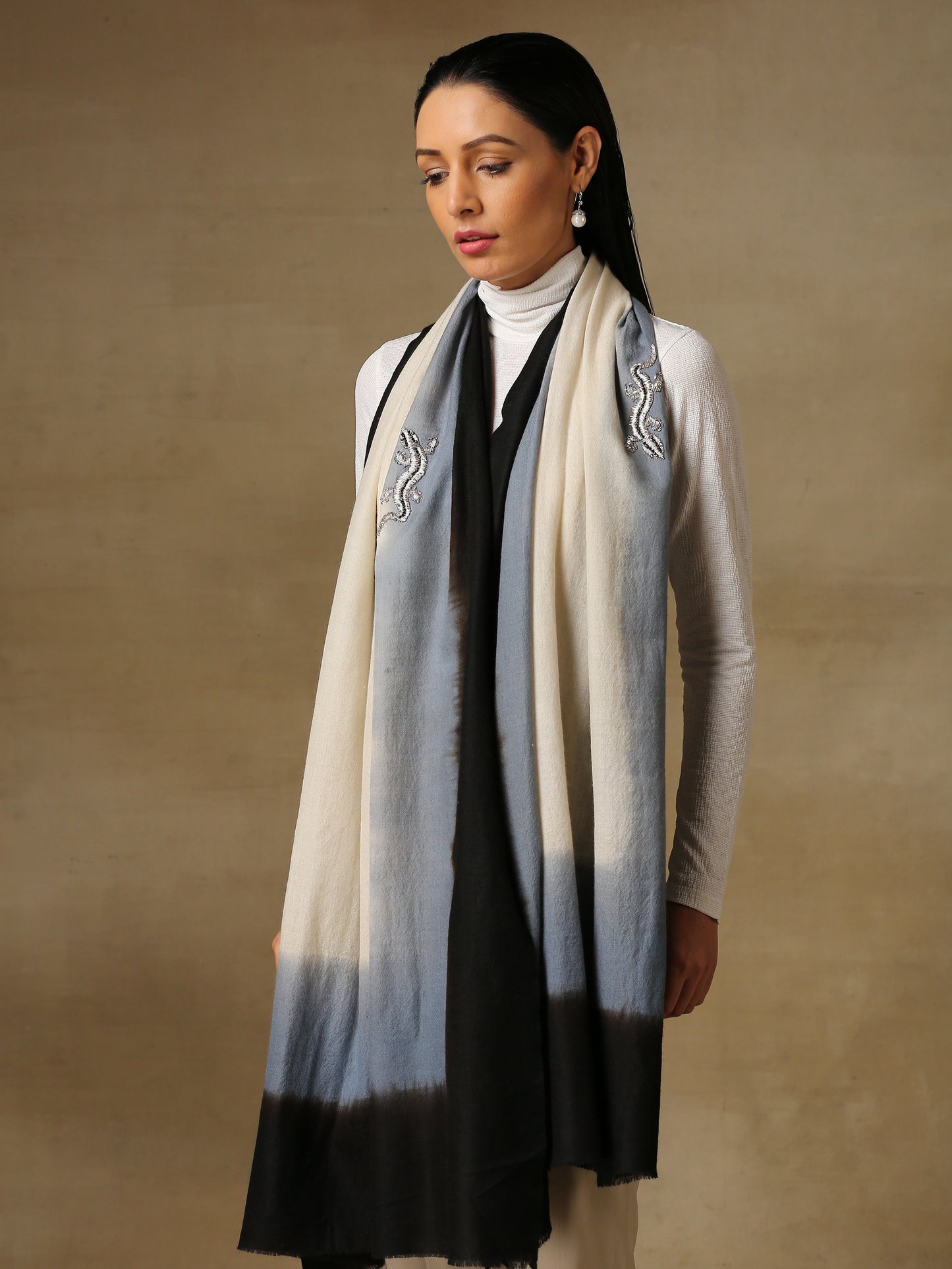 Model is wearing a Reptile Pashmina stole from shaza, featuring a hand painted ombre in the colour caves and tinsel and swarovski adorned sinuous shapes.