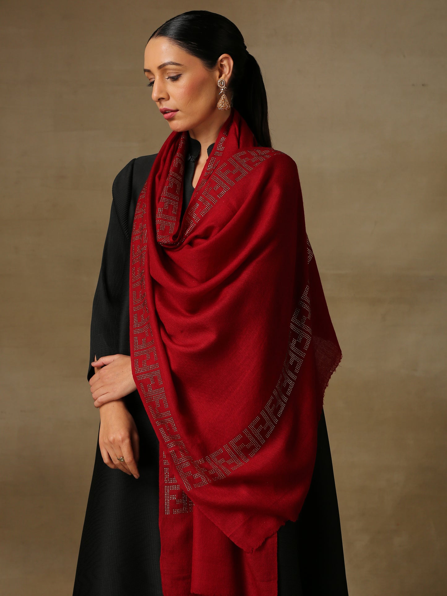 Model is wering a maroon coloured stole from the Era of Zaywar Border Swarovski Stole collection, hand embellished with gold swarovski in an abstract design.
