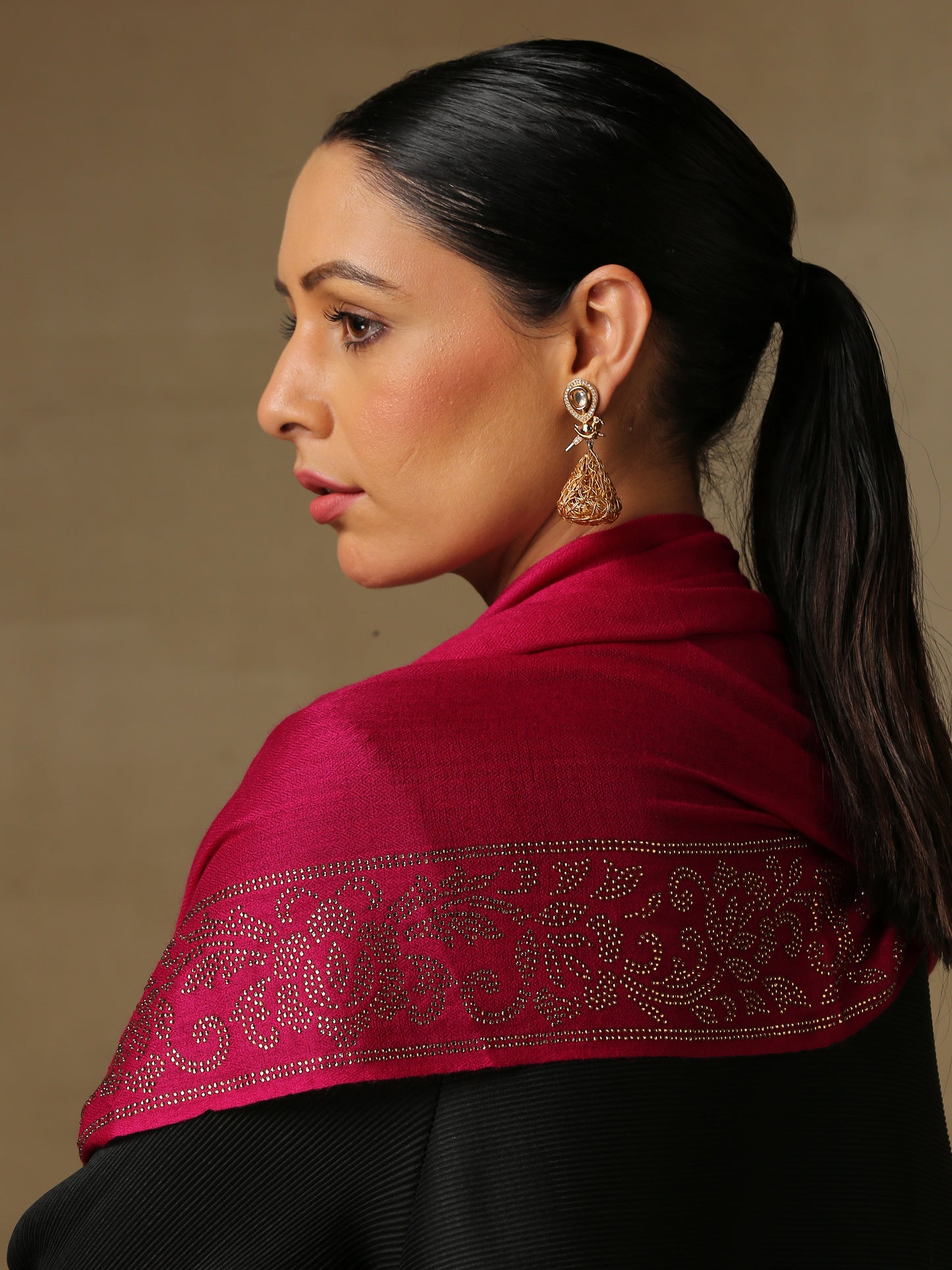 Model is wearing a magenta coloured stole from the Era of Zaywar Border Swarovski Stole collection, hand embellished with gold swarovski in the shape of a vine.