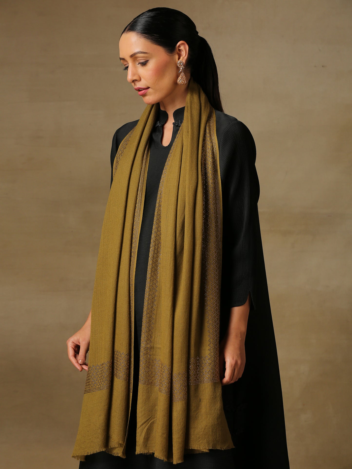 Model is wearing a henna coloured stole from the Era of Zaywar Border Swarovski Stole collection, hand embellished with gold swarovski in a cubes design.