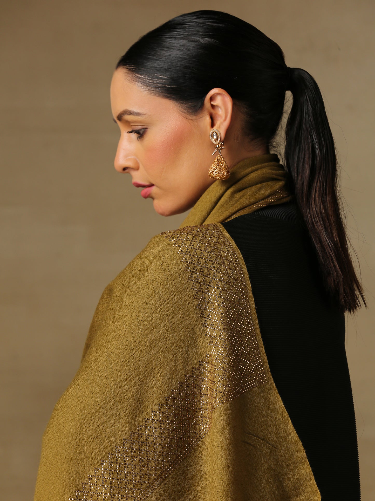 Model is wearing a henna coloured stole from the Era of Zaywar Border Swarovski Stole collection, hand embellished with gold swarovski in a cubes design.