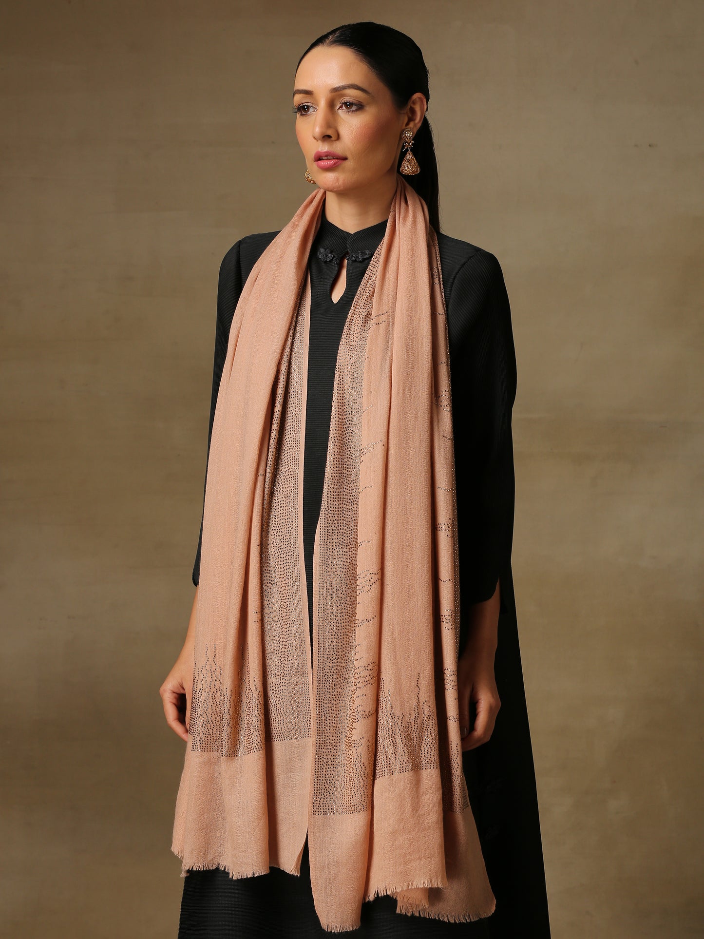 The model is wearing a blush coloured stole from the Era of Zaywar Border Swarovski Stole collection, hand embellished with fine gold swarovski in a flames of fire design.