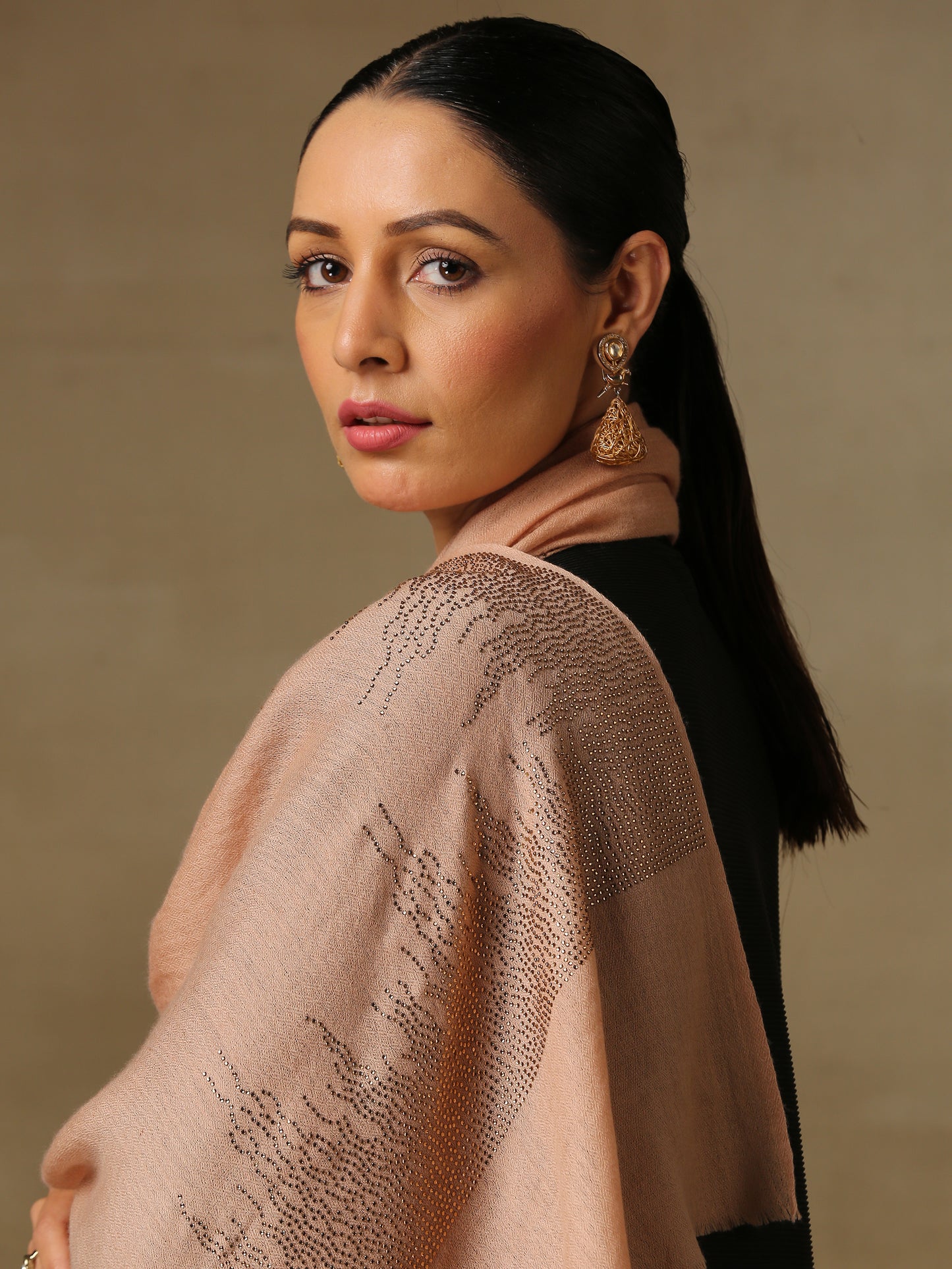 The model is wearing a blush coloured stole from the Era of Zaywar Border Swarovski Stole collection, hand embellished with fine gold swarovski in a flames of fire design.