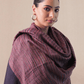 Woman wearing a large purple scarf against a beige background