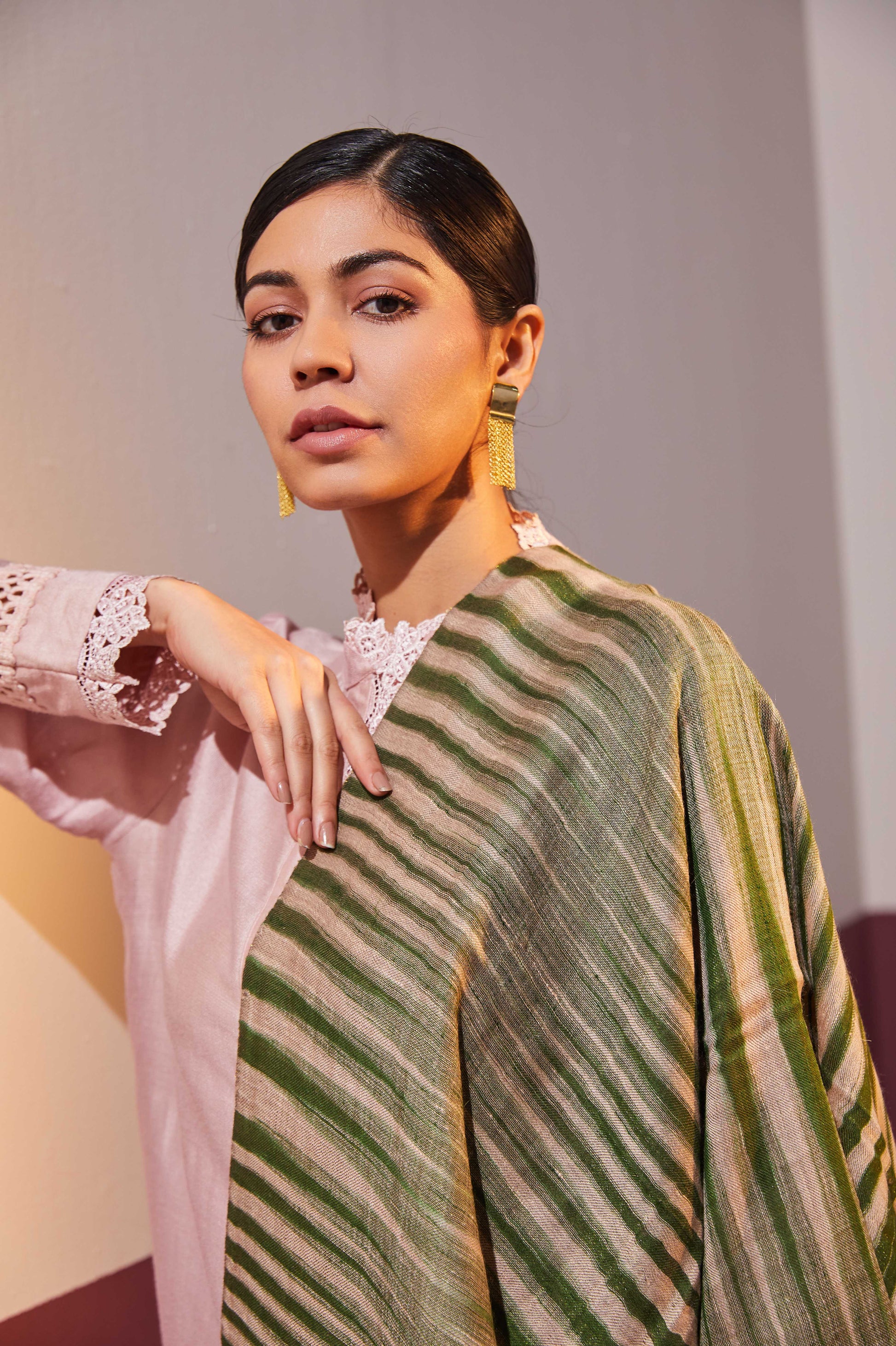 Model is wearing an Ekkat reversible stole in seaweed green from Shaza.