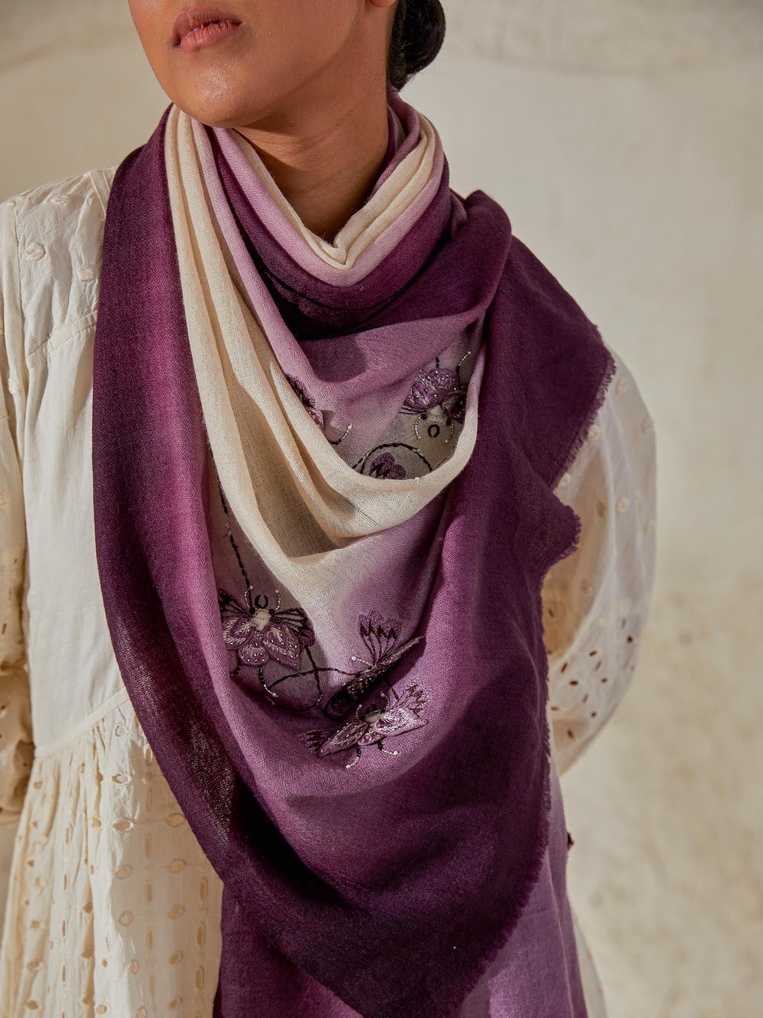 Model is wearing a Beetle pashmina stole from Shaza in the colour orchid, featuring threadwork beetle shapes uplifted with hand embroidered pearls, sequins and swarovski.