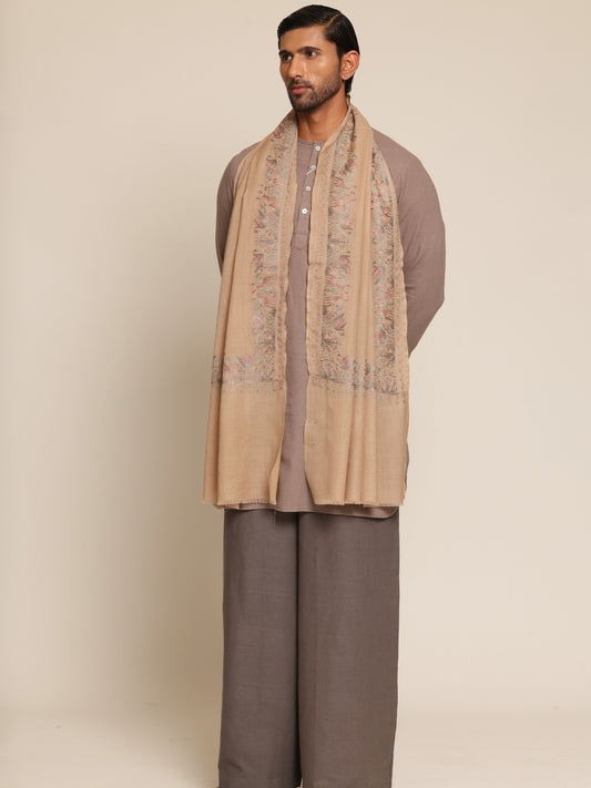 Man wearing a beige stole and brown outfit