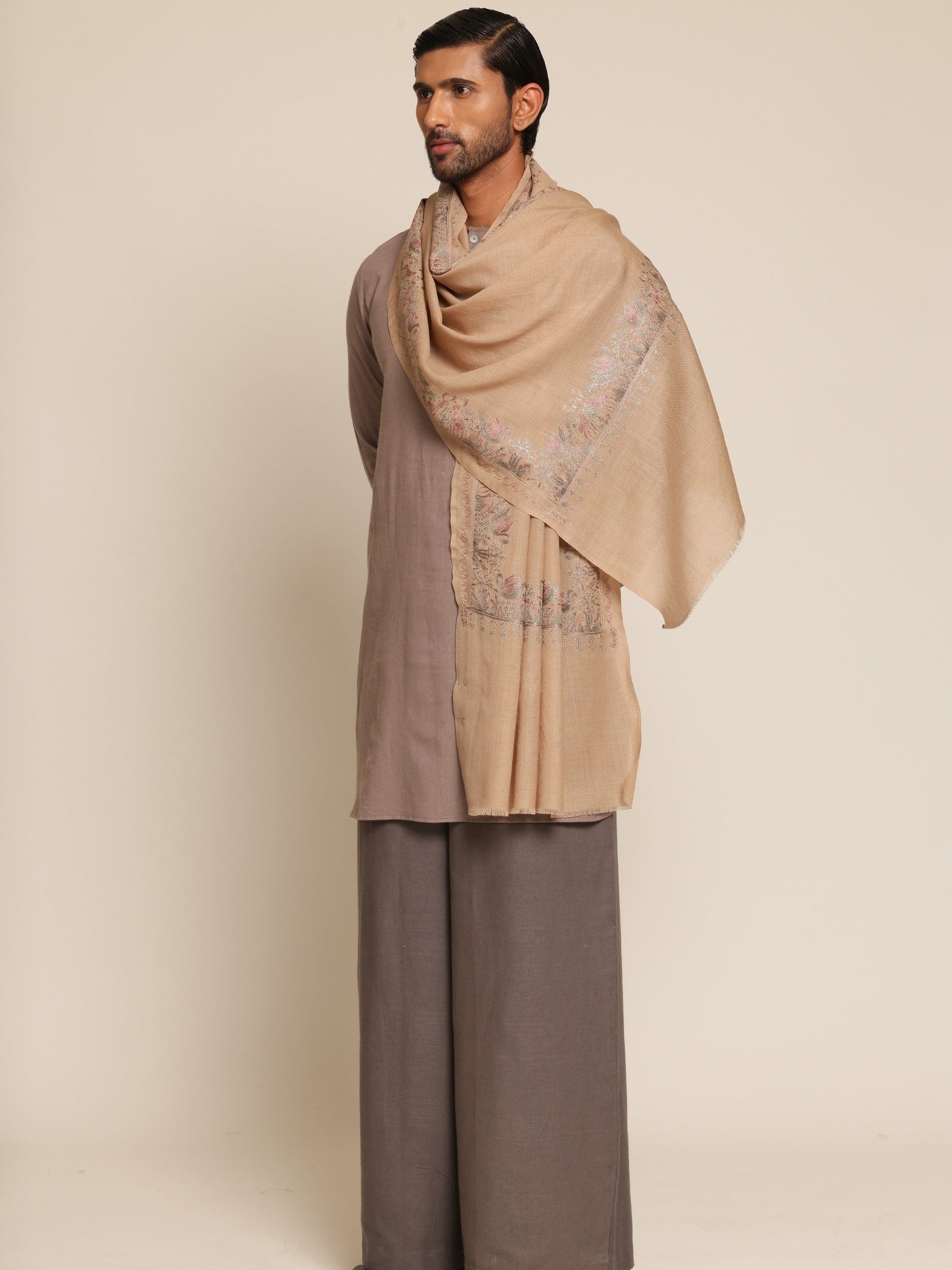 Man wearing a beige stole and brown outfit