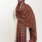 Man wearing a maroon and mustard check shawl.